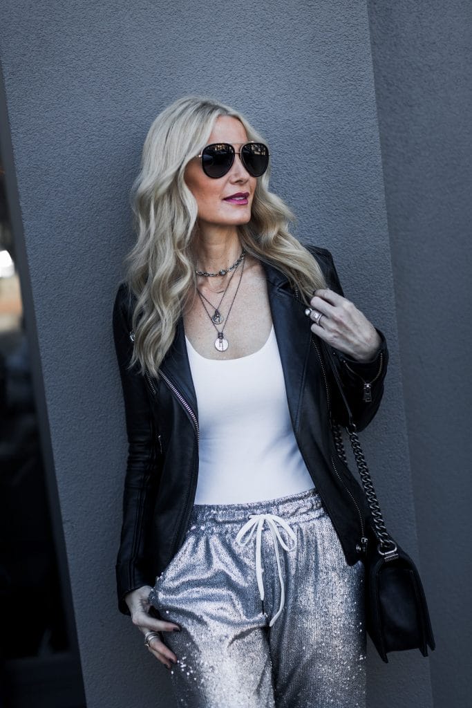 Dallas blonde woman wearing leather jacket and sequin joggers 