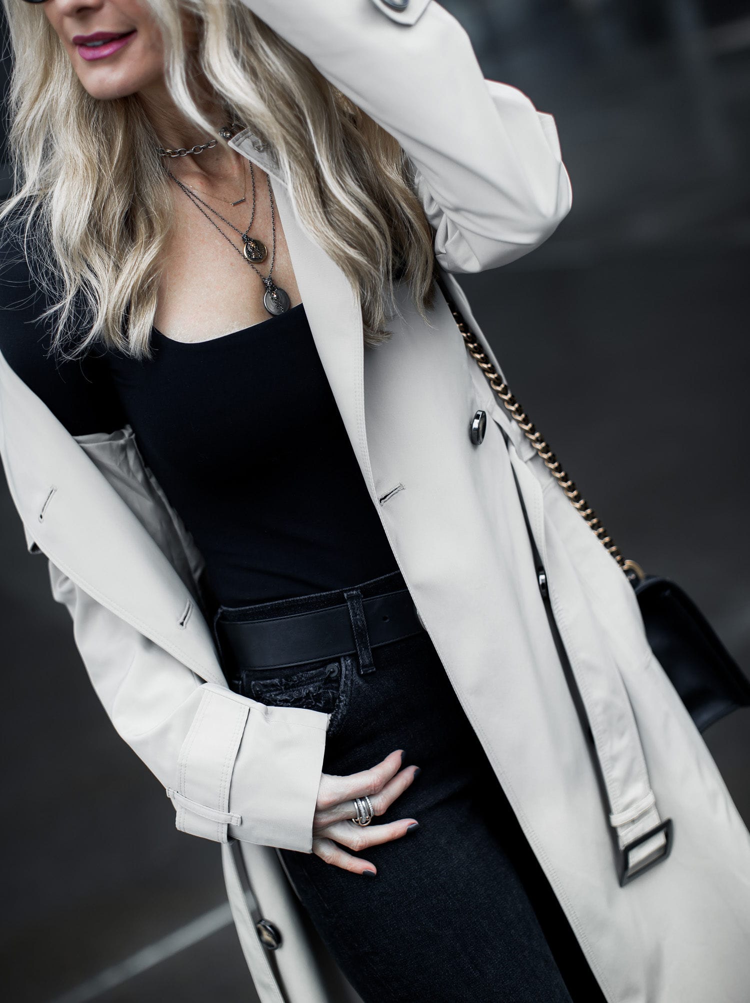 Dallas blonde woman wearing black skinny jeans and a classic trench coat 