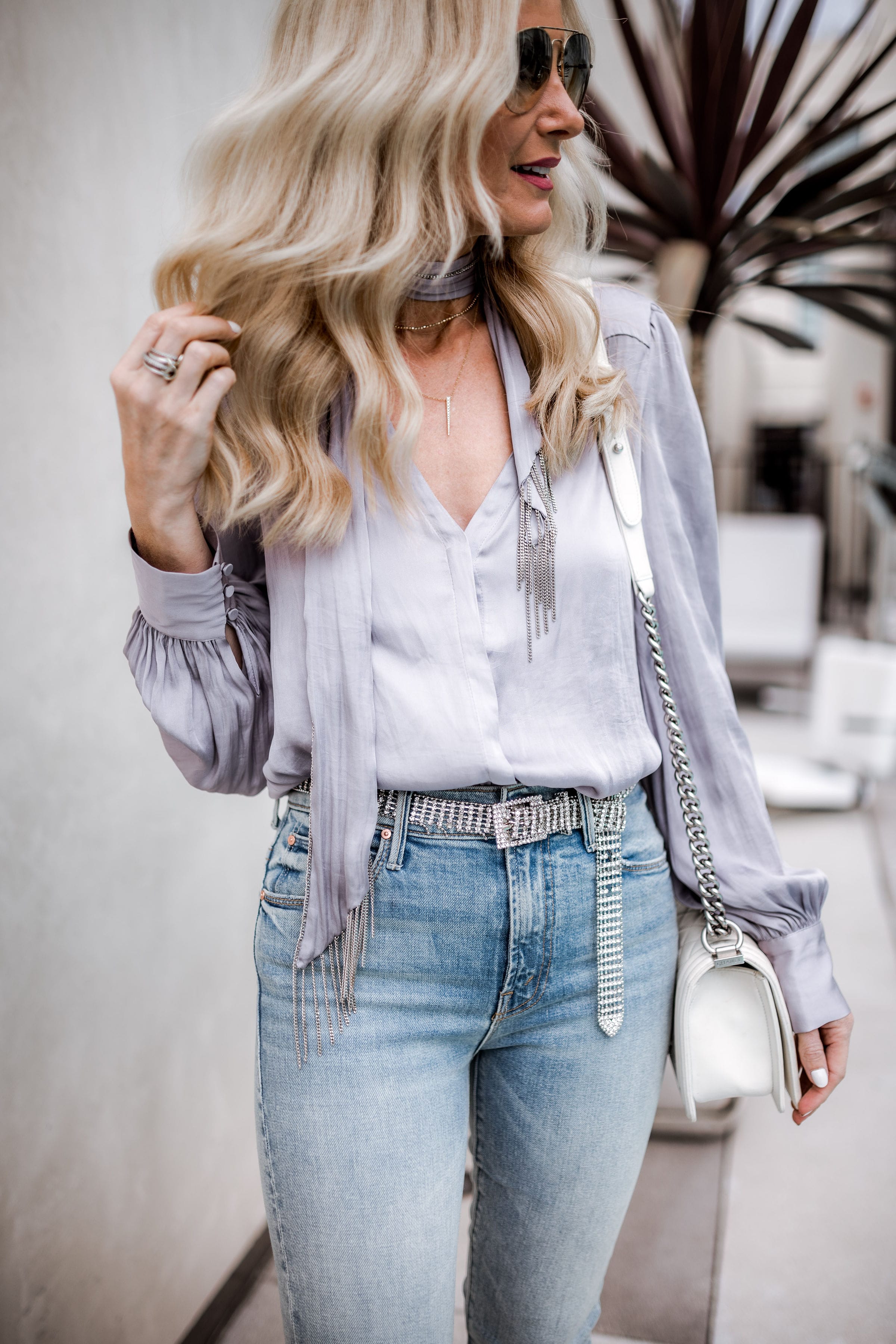 Dallas blonde woman wearing satin top and Mother denim skinny jeans 