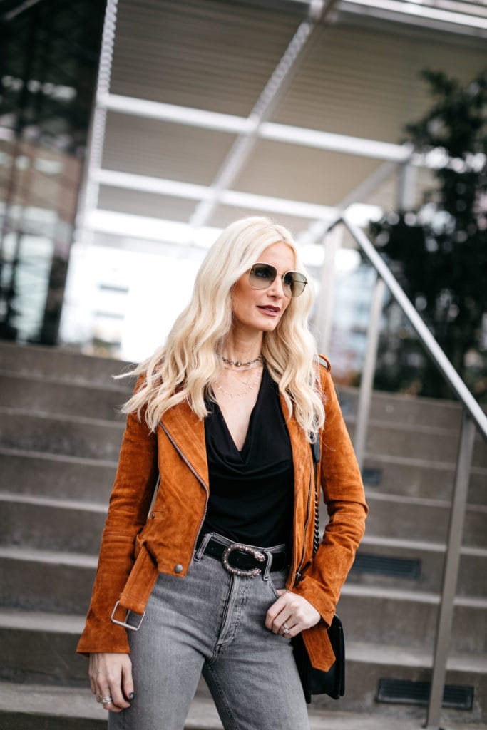 Fashion blogger wearing an orange moto jacket and a Gucci belt