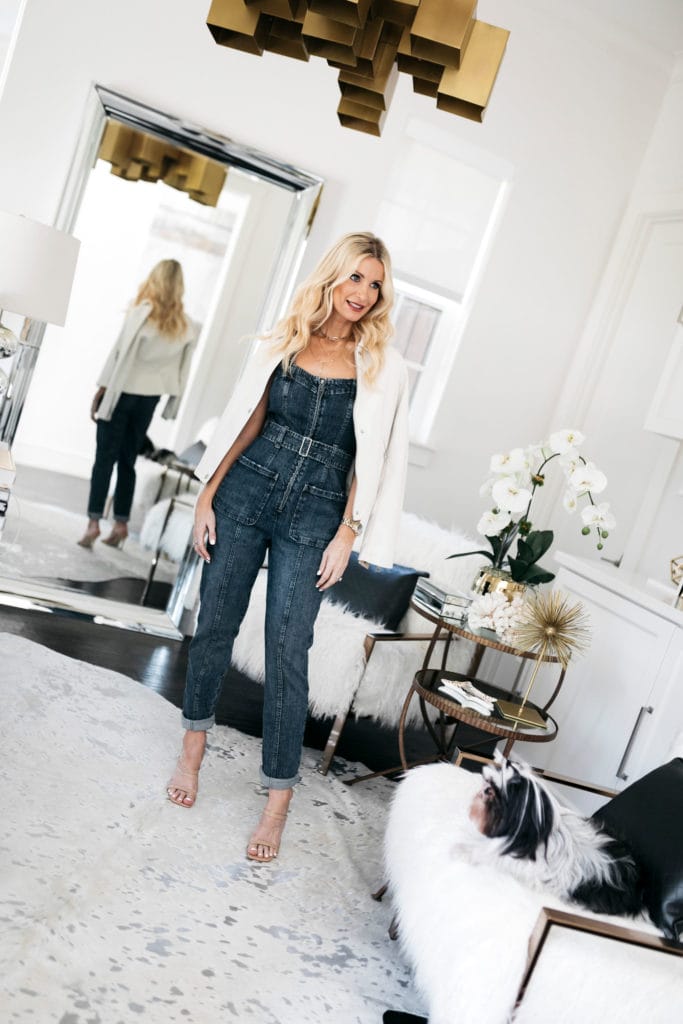 Style blogger wearing a denim jumpsuit and a white jacket
