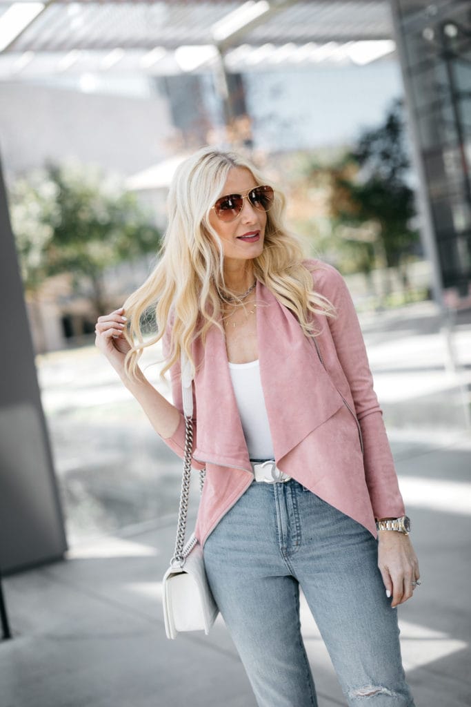 Dallas woman wearing a blush pink moto jacket 