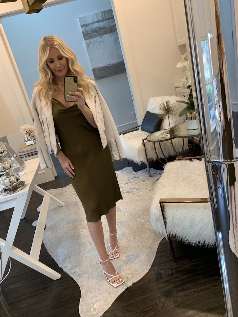 Style influencer wearing an olive green midi dress and white heels