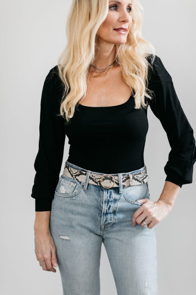 Dallas influencer wearing a black puff sleeve top and denim