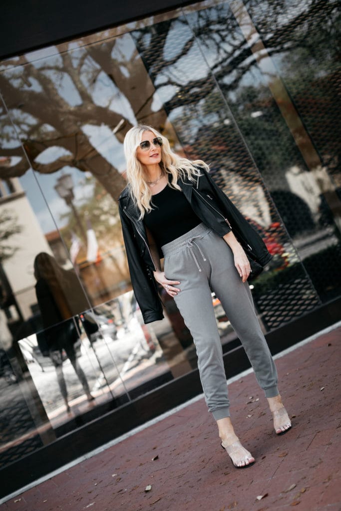 Dallas blogger wearing a leather jacket and gray joggers with heels