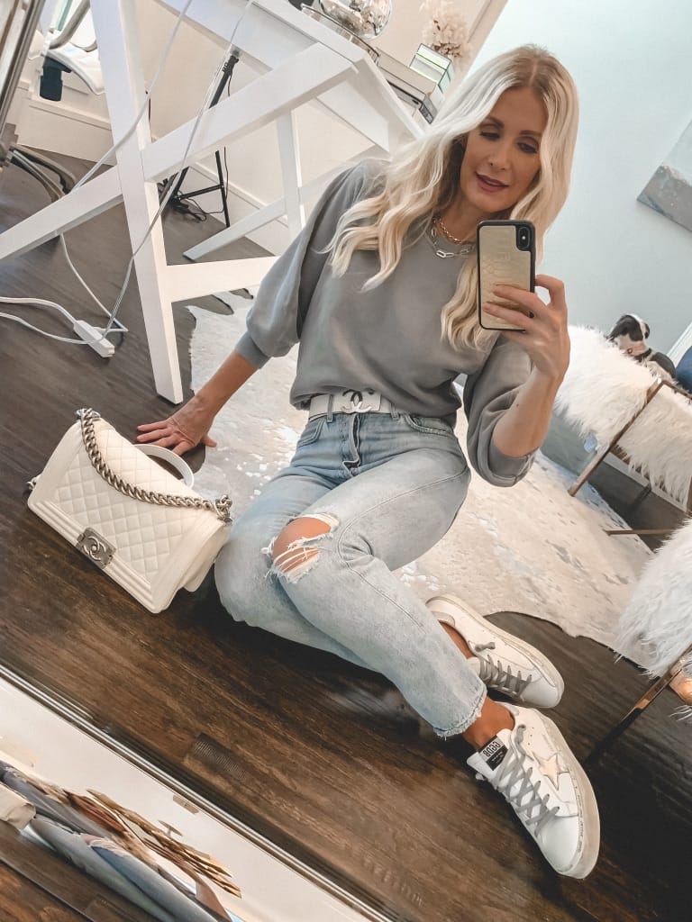 Style blogger wearing a grey sweatshirt and light wash denim