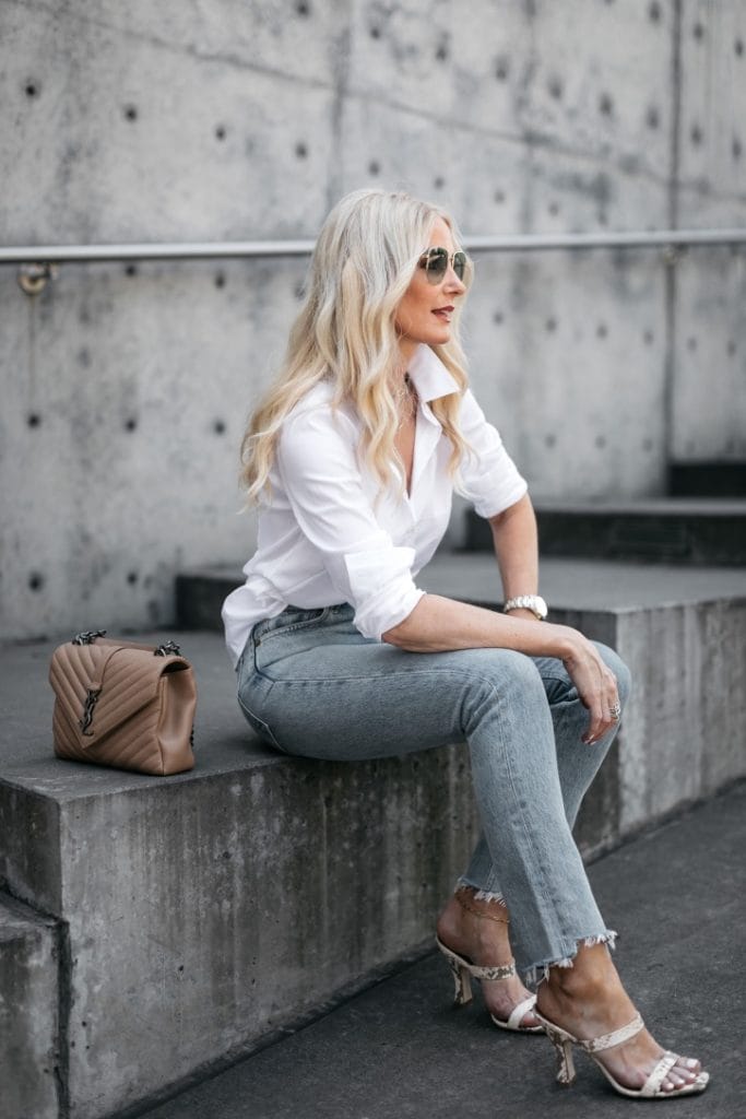Style blogger wearing a white button down blouse and denim