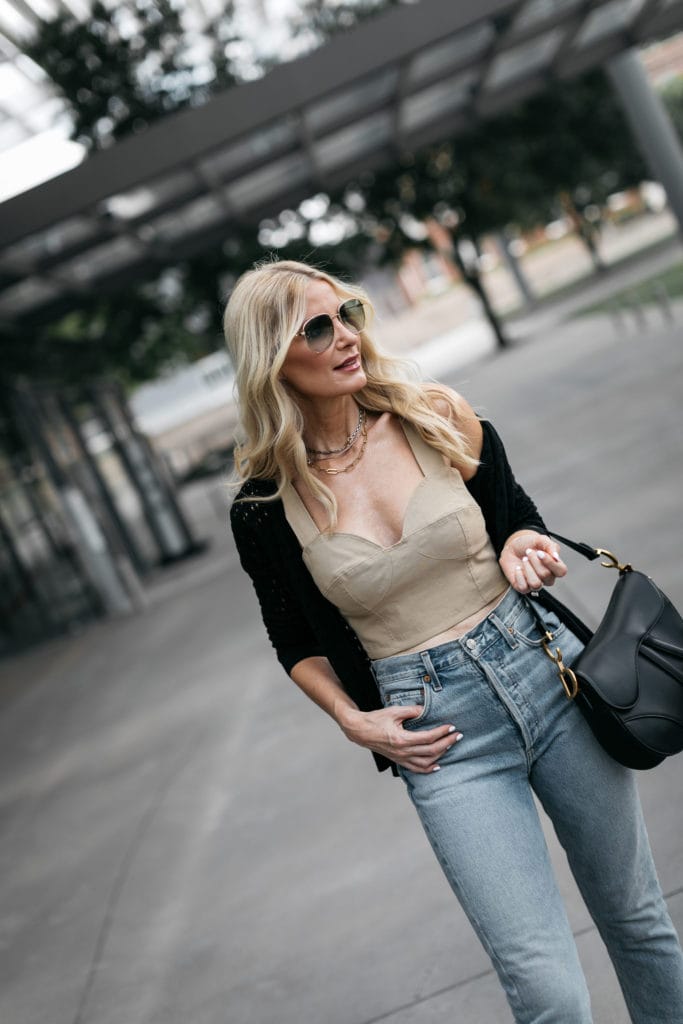 Style blogger wearing a neutral crop top with a black knit sweater