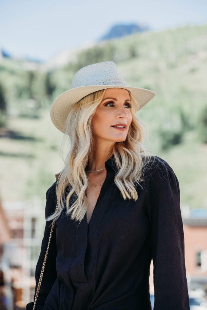 Dallas blogger in Telluride wearing a black dress and a summer hat