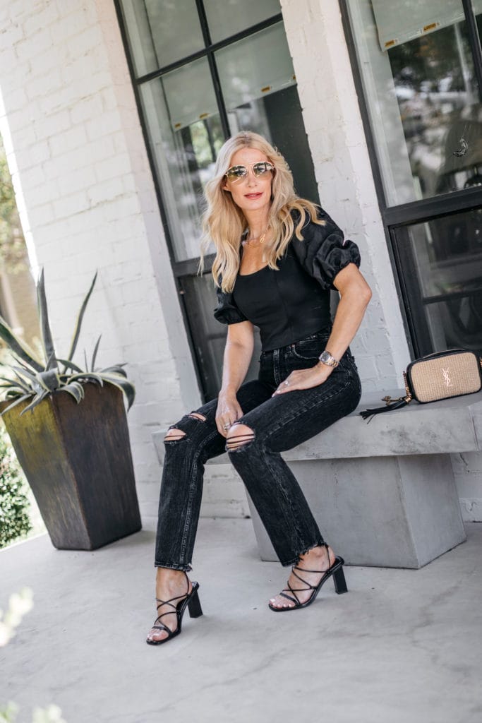Dallas style blogger wearing ripped black denim and a black puff-sleeve top