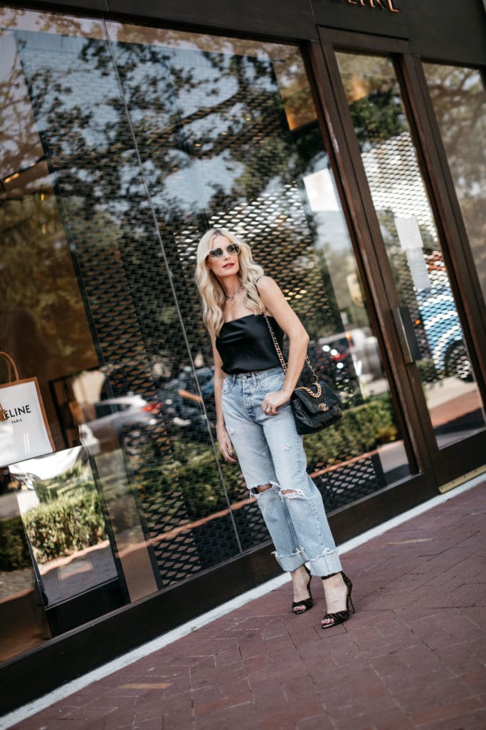 Fashion blogger wearing a strapless black top and cropped denim for fall