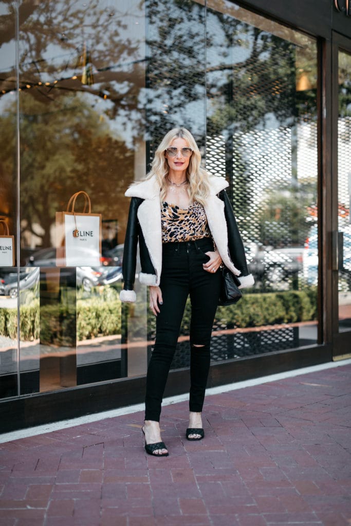 Dallas blogger wearing a black and fur shearling jacket with black denim and black heels 