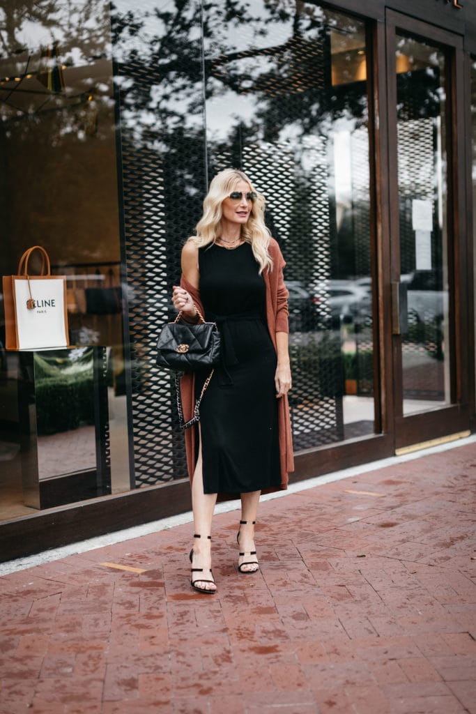 Dallas blogger wearing a black dress and a rust long cardigan