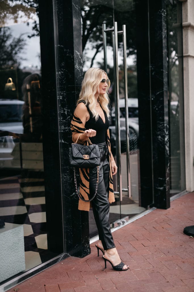 Style influencer wearing black faux leather leggings and a black bodysuit