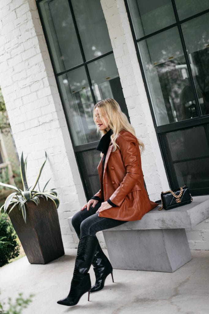 Dallas blogger wearing a rust faux leather jacket and knee-high black boots by Schutz