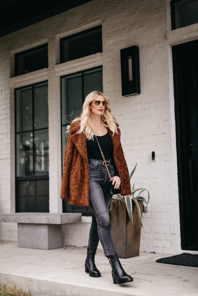 Fashion blogger wearing a faux fur jacket and black faded denim