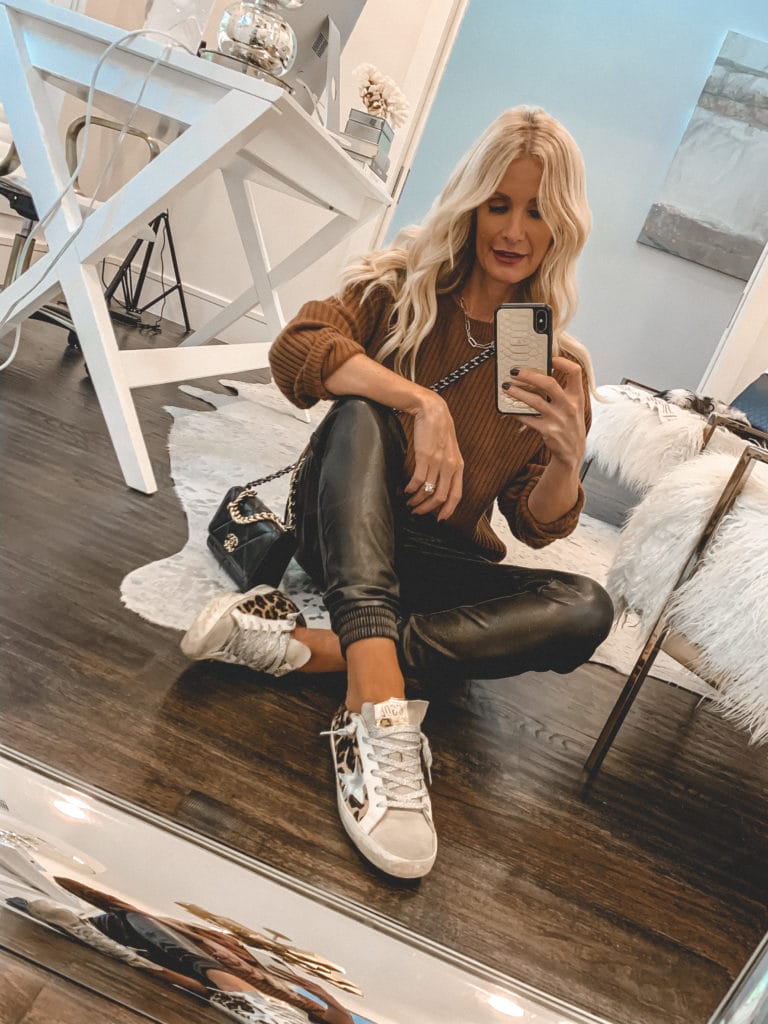 Fashion blogger wearing faux leather joggers and comfortable cheetah sneakers for fall