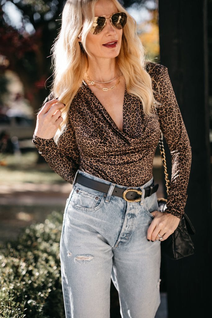 Style blogger wearing a cheetah print bodysuit and light wash denim