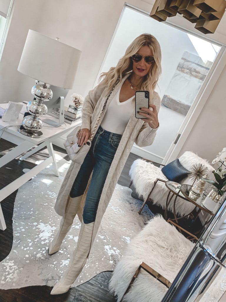 Fashion blogger wearing a long neutral cardigan and white boots for winter