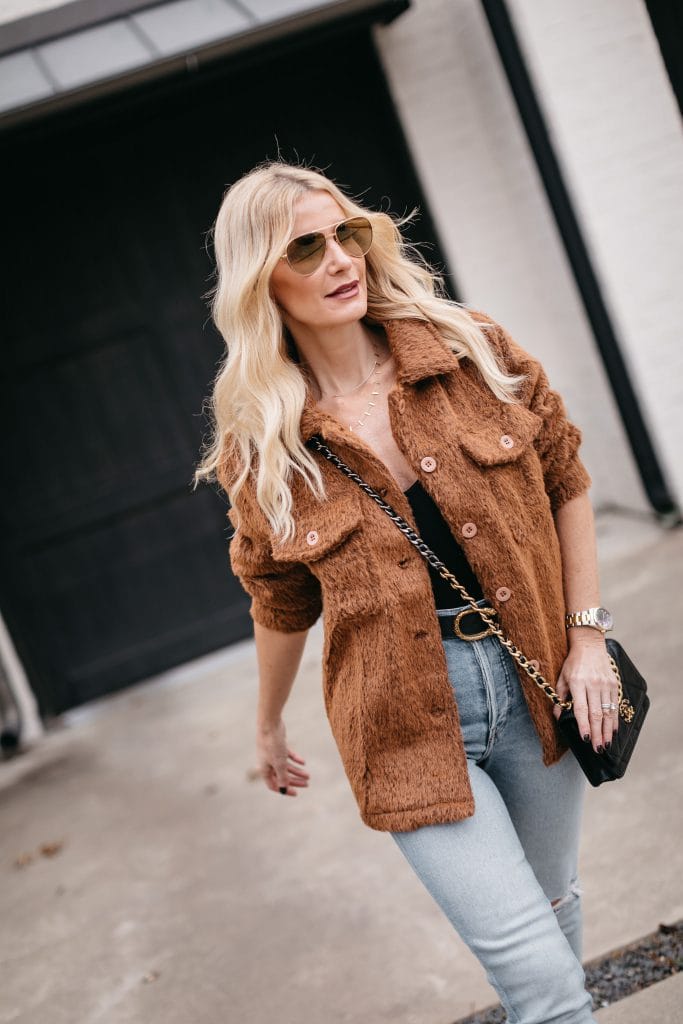 Dallas style blogger wearing a camel colored teddy shirt jacket with a Gucci belt and a black bodysuit 