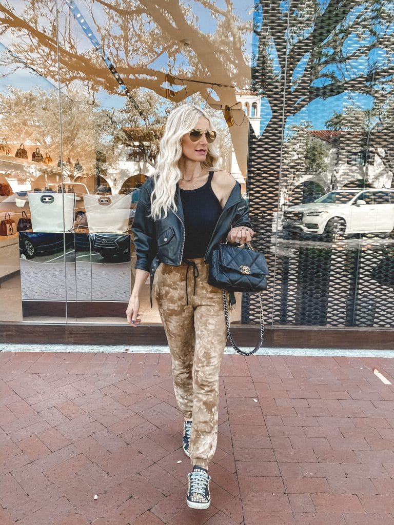 Dallas blogger wearing neutral tie dye joggers and a black Moto jacket