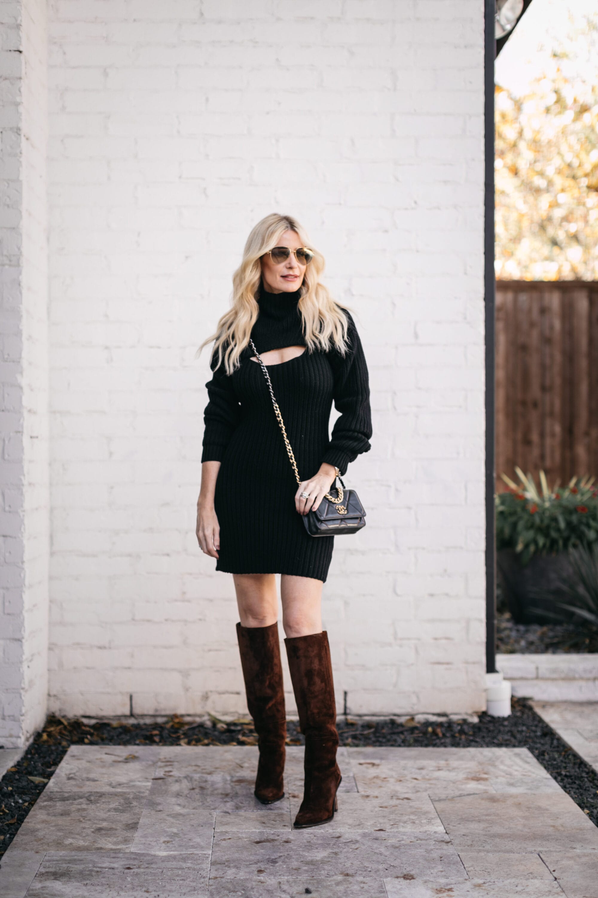 Dallas fashion blogger wearing a black sweater dress and brown knee high boots