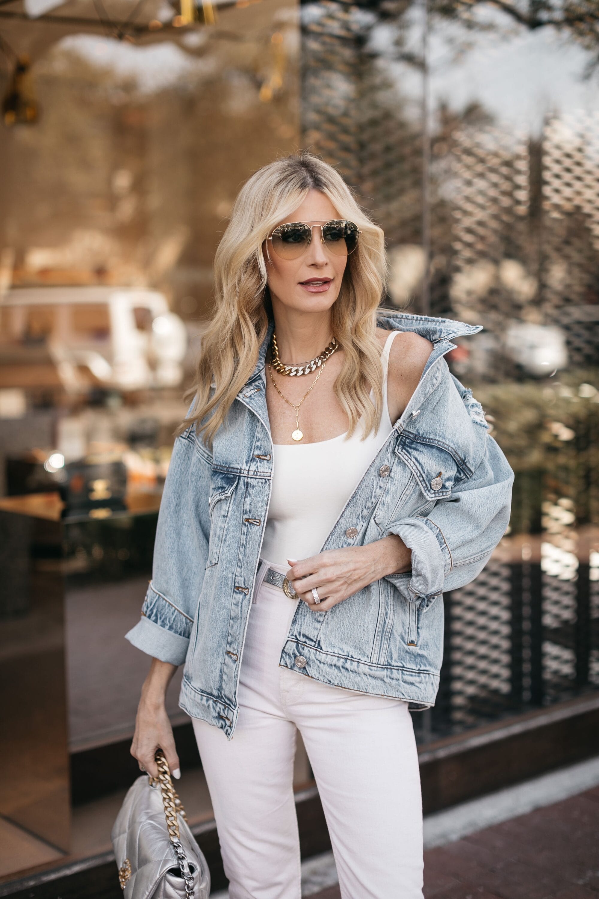 Dallas woman over 40 wearing oversized jean jacket over all white bodysuit and jeans