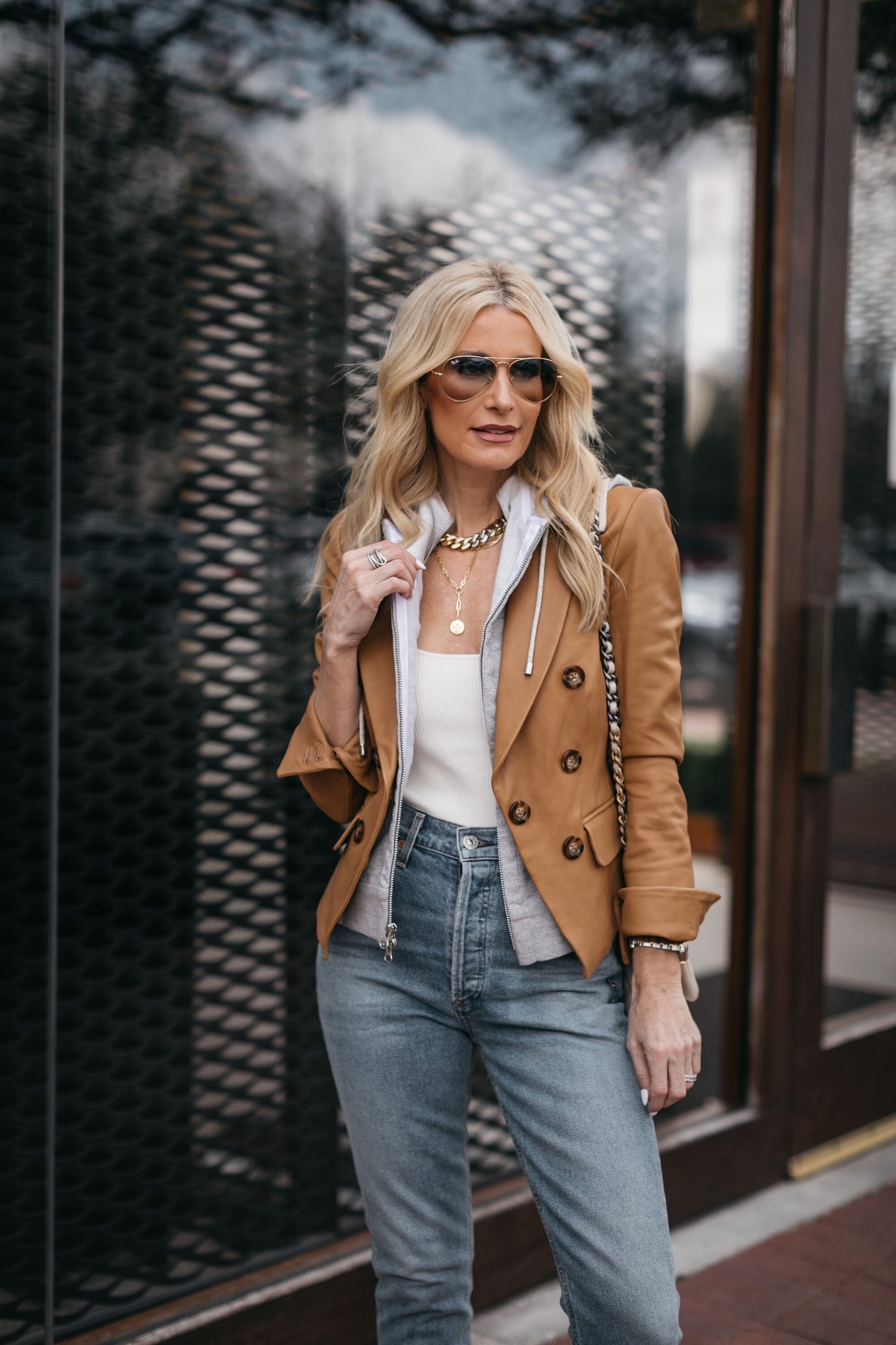 Dallas woman wearing casual look of camel blazer with grey dicky, white bodysuit, denim and aviator sun glasses
