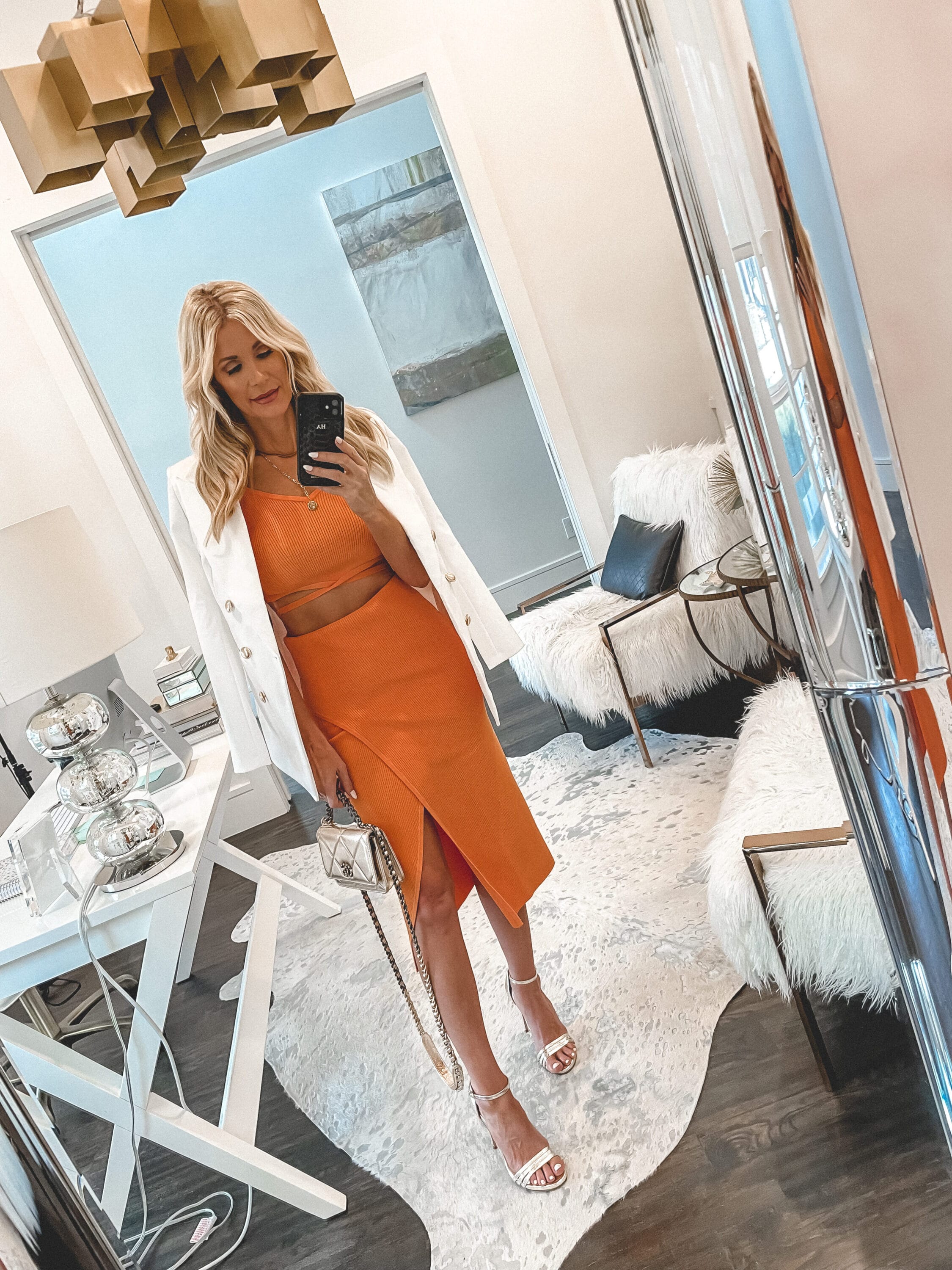 Dallas fashion blogger over 40 wearing orange midi skirt with matching crop top and oversized white blazer