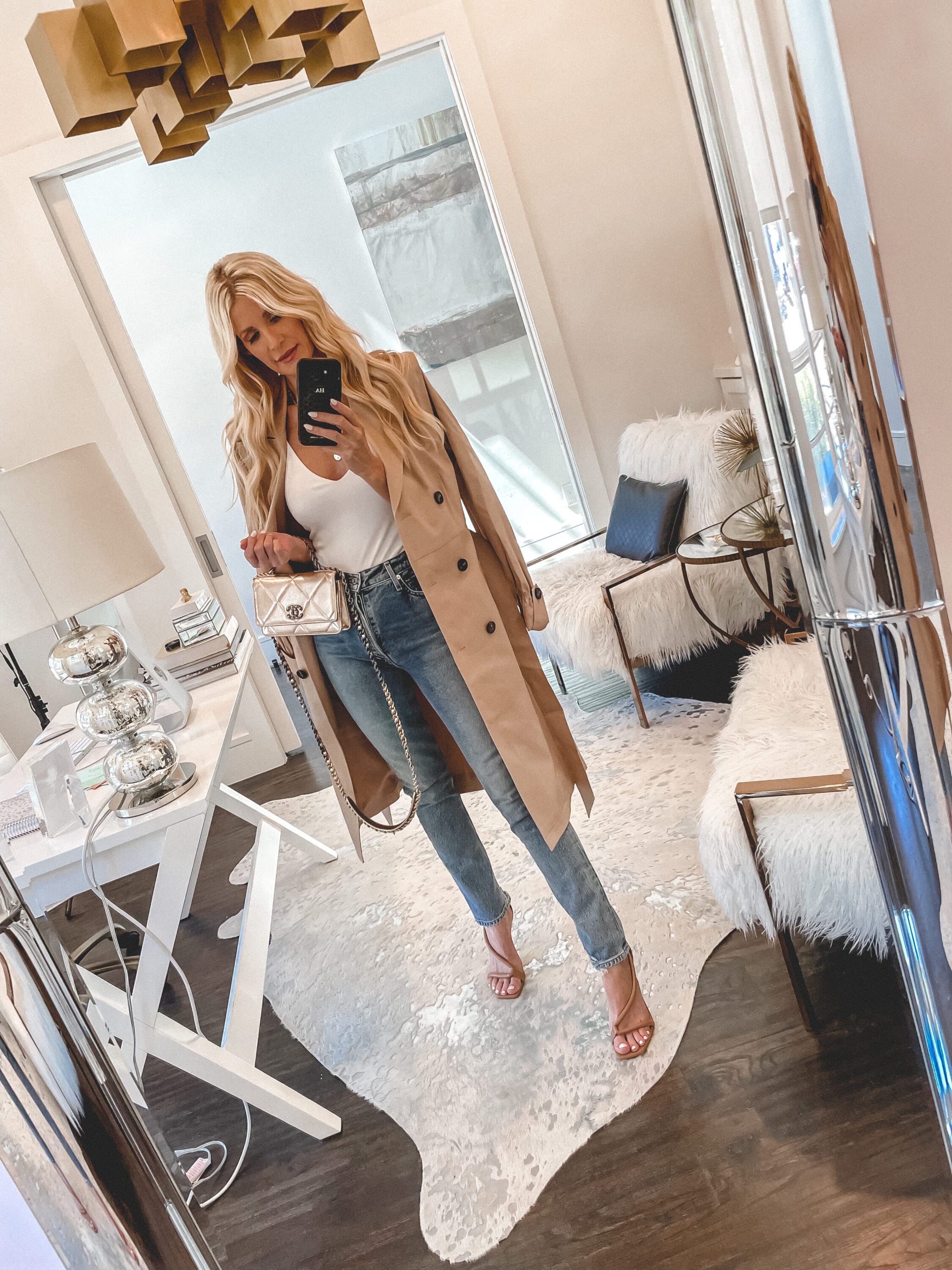Dallas fashion blogger over 40 wearing beige trench coat over white tank with high-waisted denim