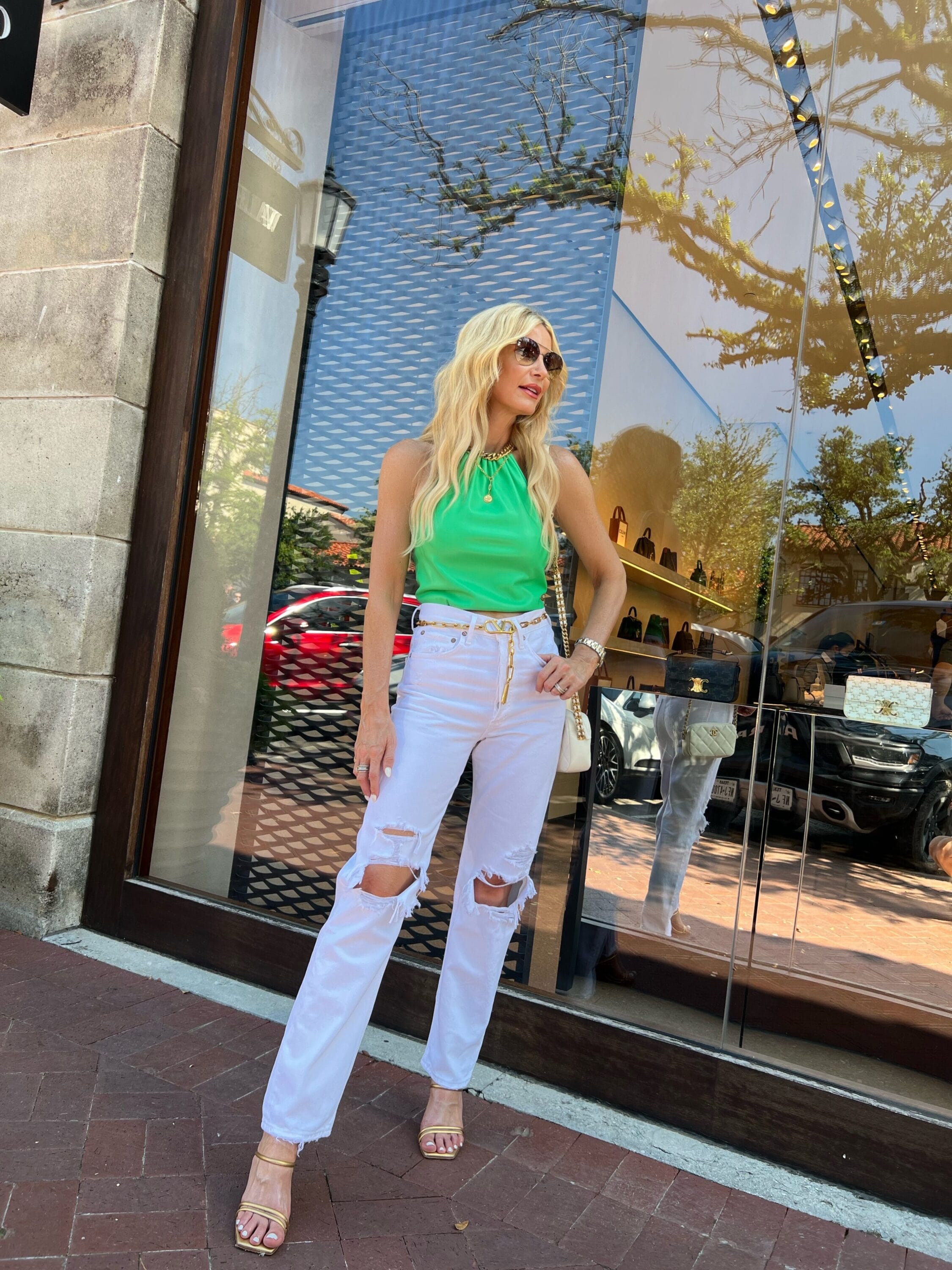 Dallas fashion blogger wearing green vegan leather top with white distressed jeans