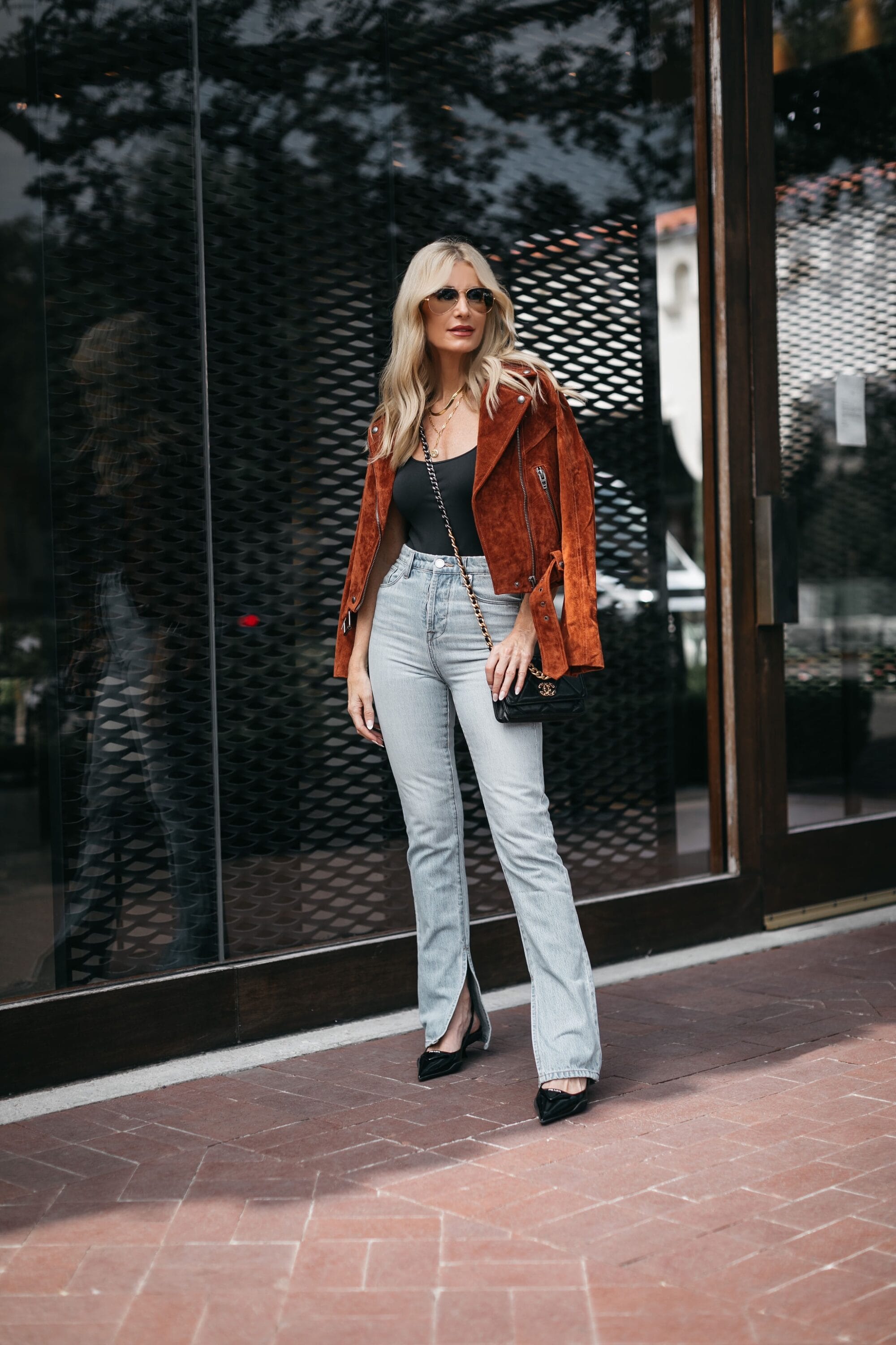 Dallas Fashion blogger wearing slit hem flares jeans with suede moto jacket and black bodysuit