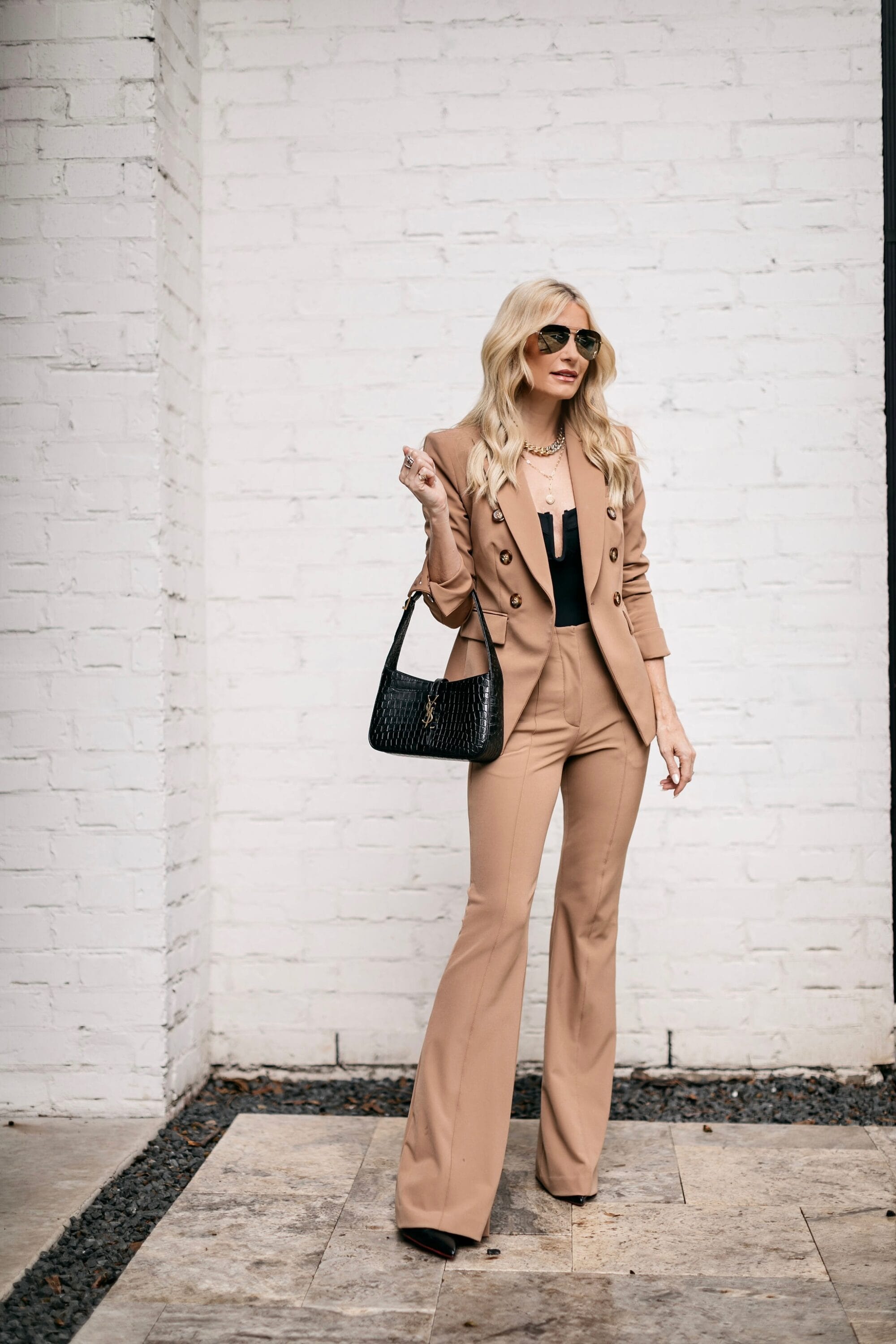 Over 40 Fashion Influencer wearing azariah pintuck pants with camel blazer and black bodysuit as part of her fall capsule wardrobe for 2022.