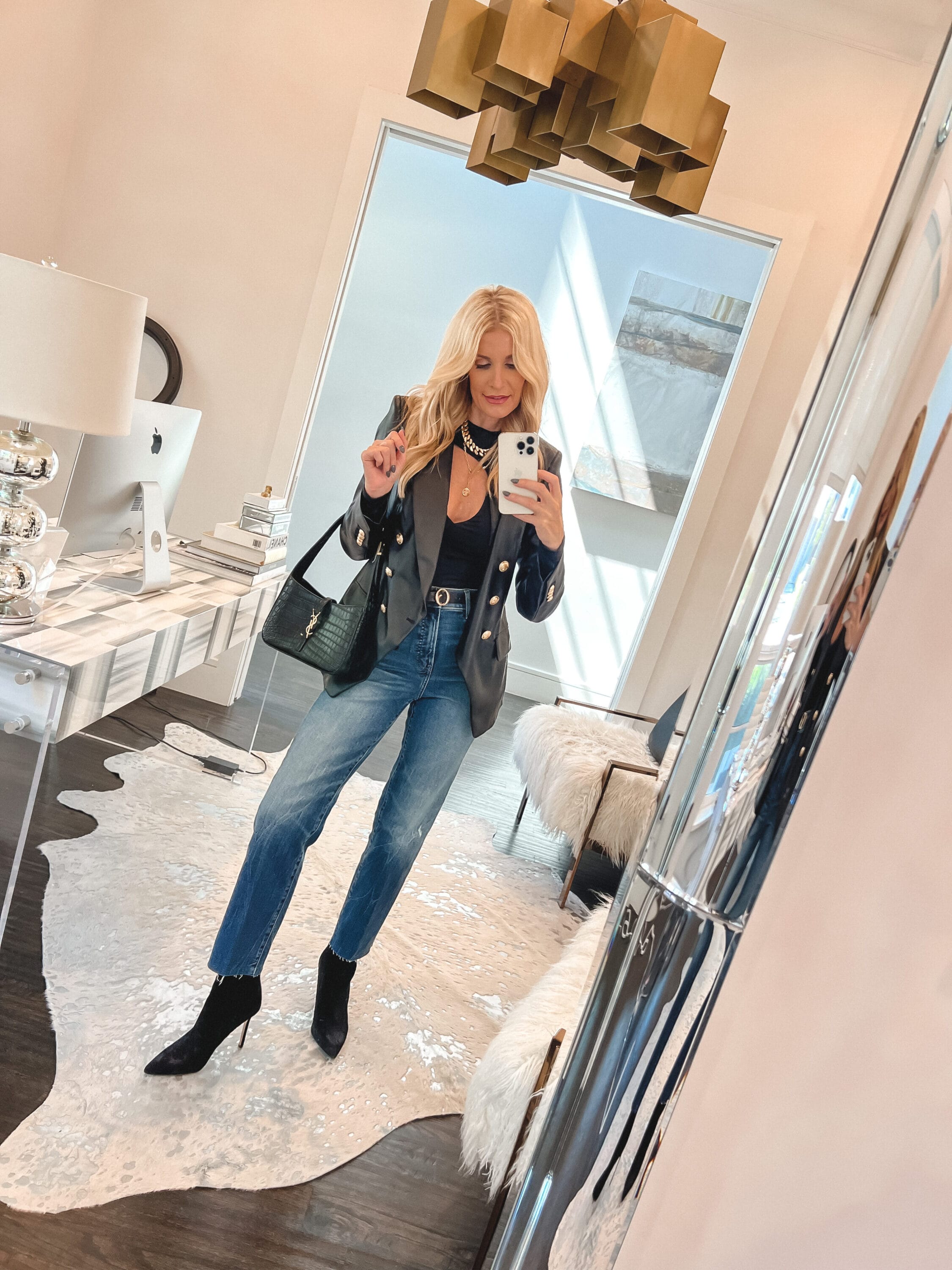 Over 40 fashion influencer wearing a black faux leather blazer from Revolve as one of October's best sellers.