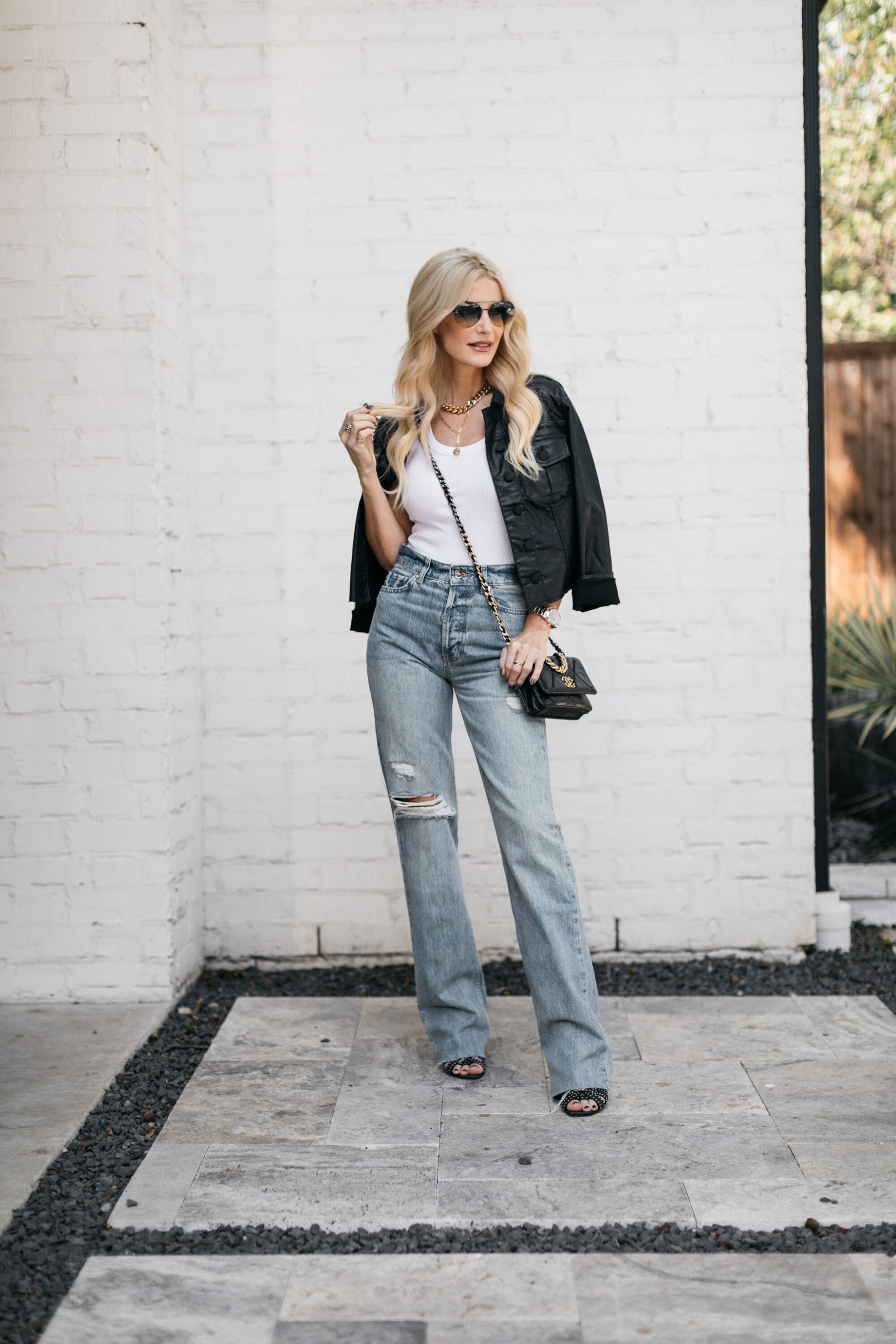 Over 40 fashion influencer wearing coated denim jacket and Anine Bing jeans.