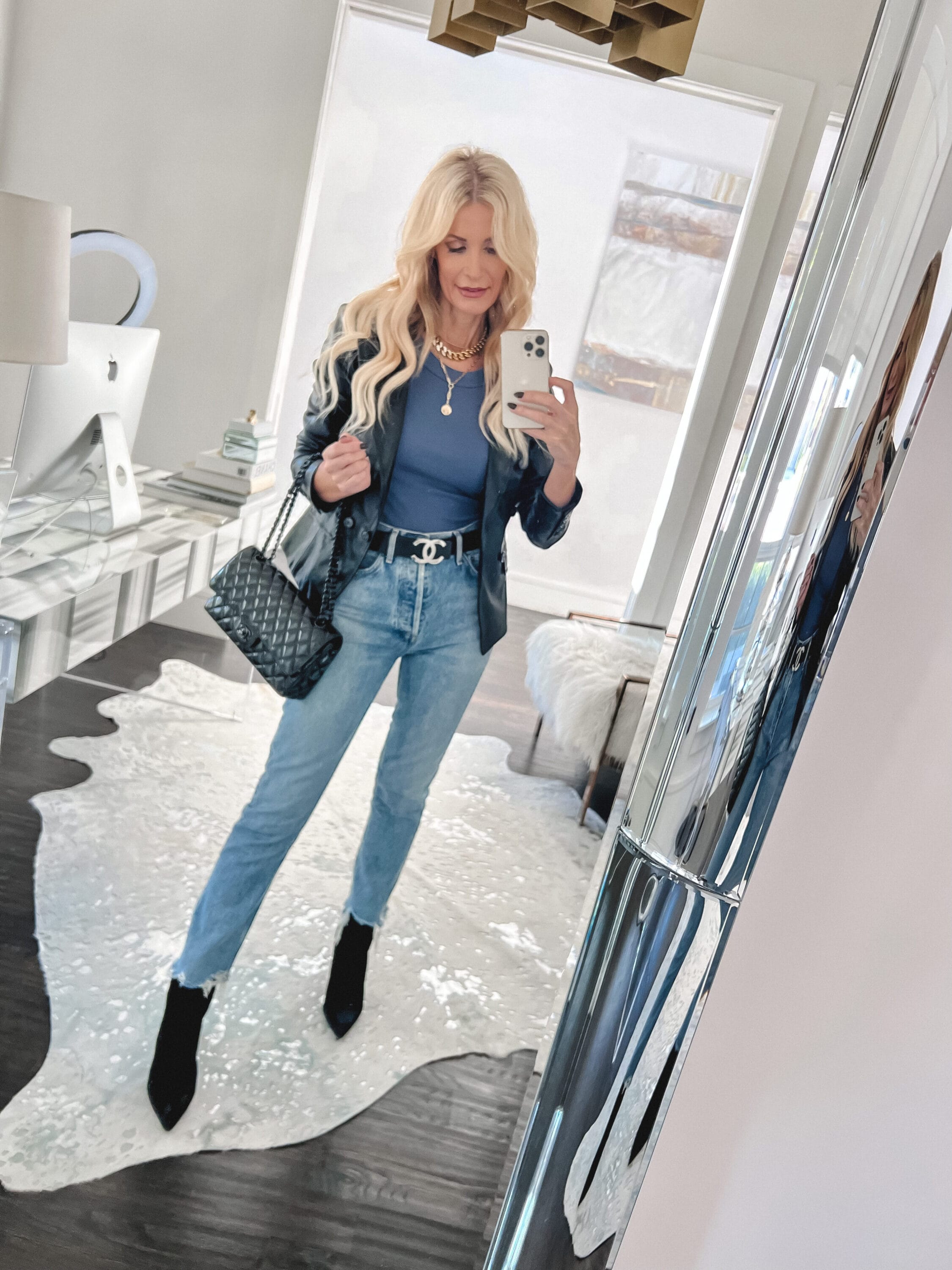 Over 40 fashion influencer wearing Evereve faux leather blazer with Riley crop jeans and black booties.