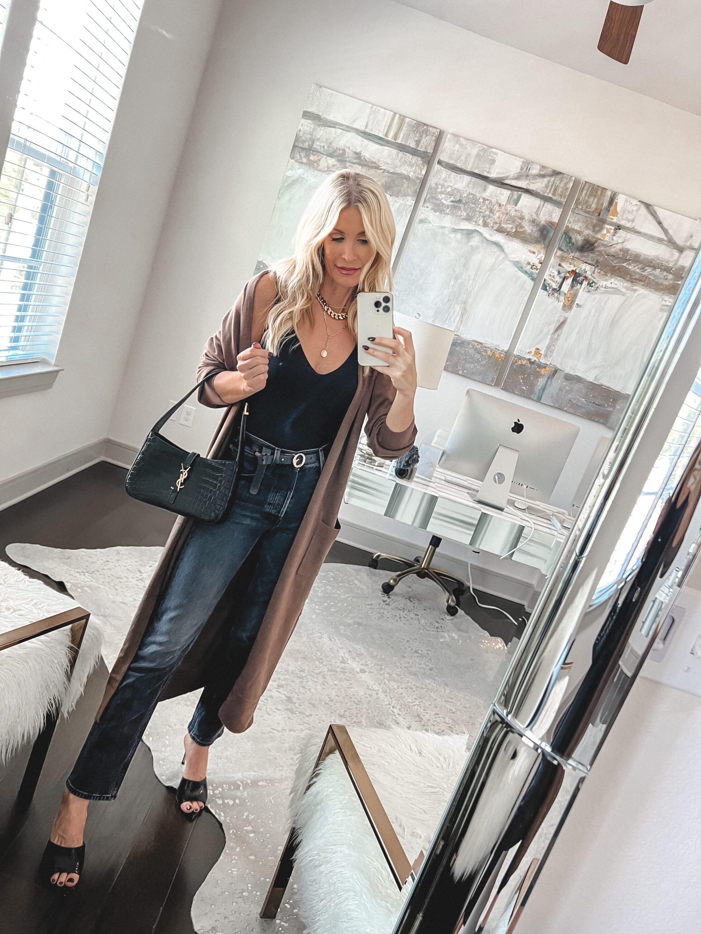 Dallas fashion blogger over 40 wearing light brown duster with dark wash jeans and black bodysuit as an example of how to wear a duster.