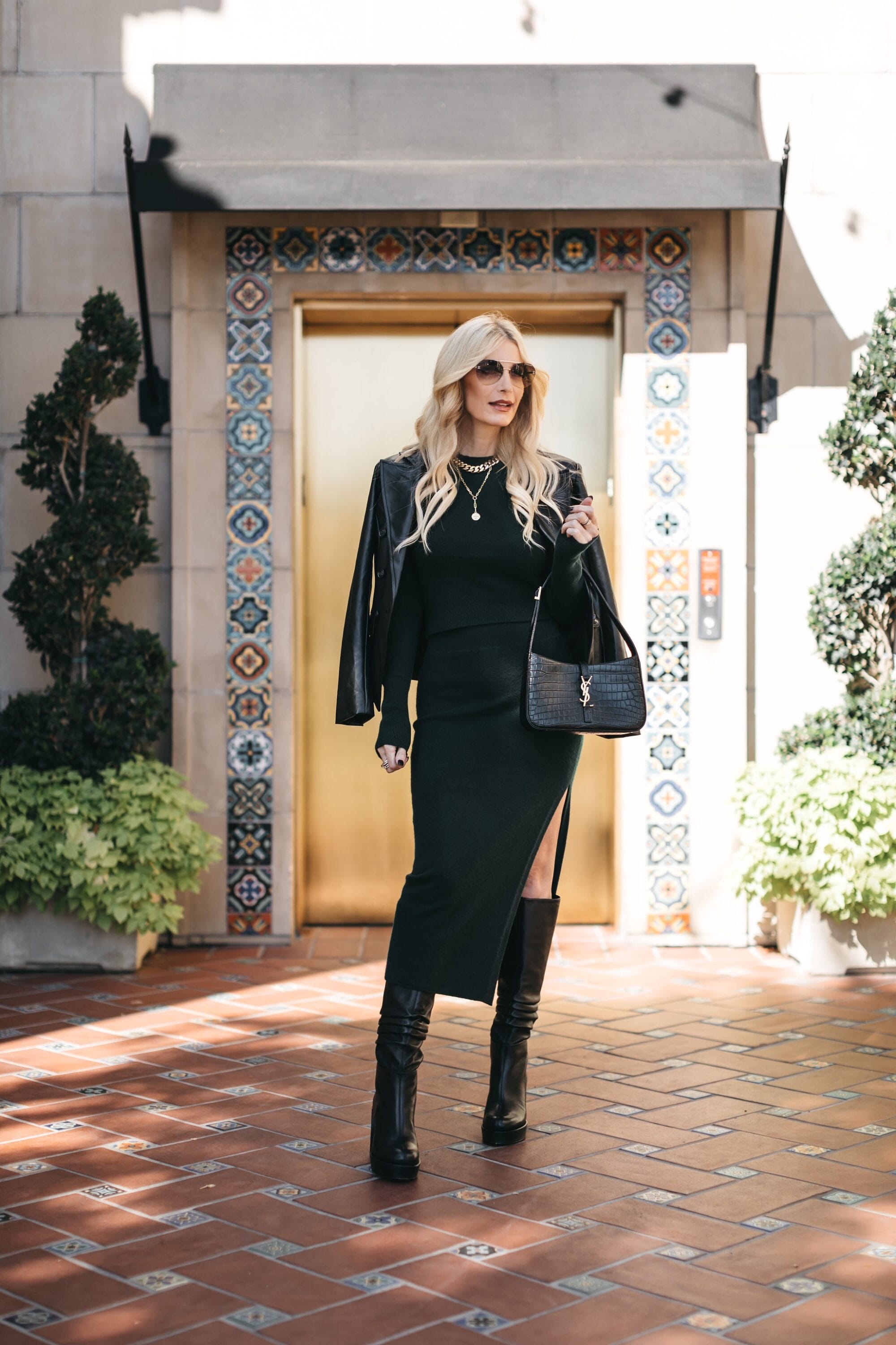 Over 40 dallas fashion blogger wearing cashmere sweater set with black faux blazer schuts knee-high boots.