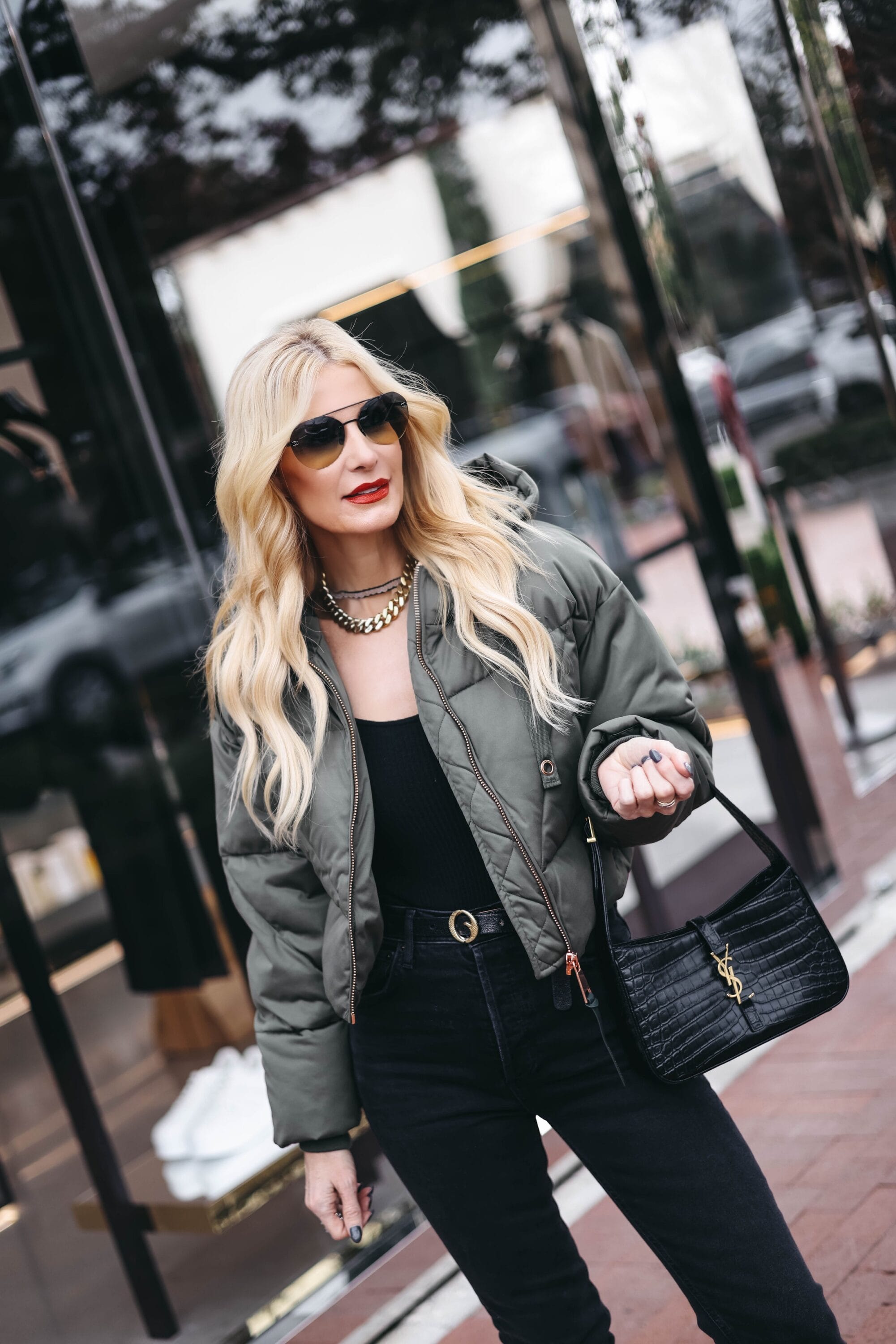 Over 40 fashion influencer wearing green puffer jacket ason of the best winter jackets your wardrobe needs.