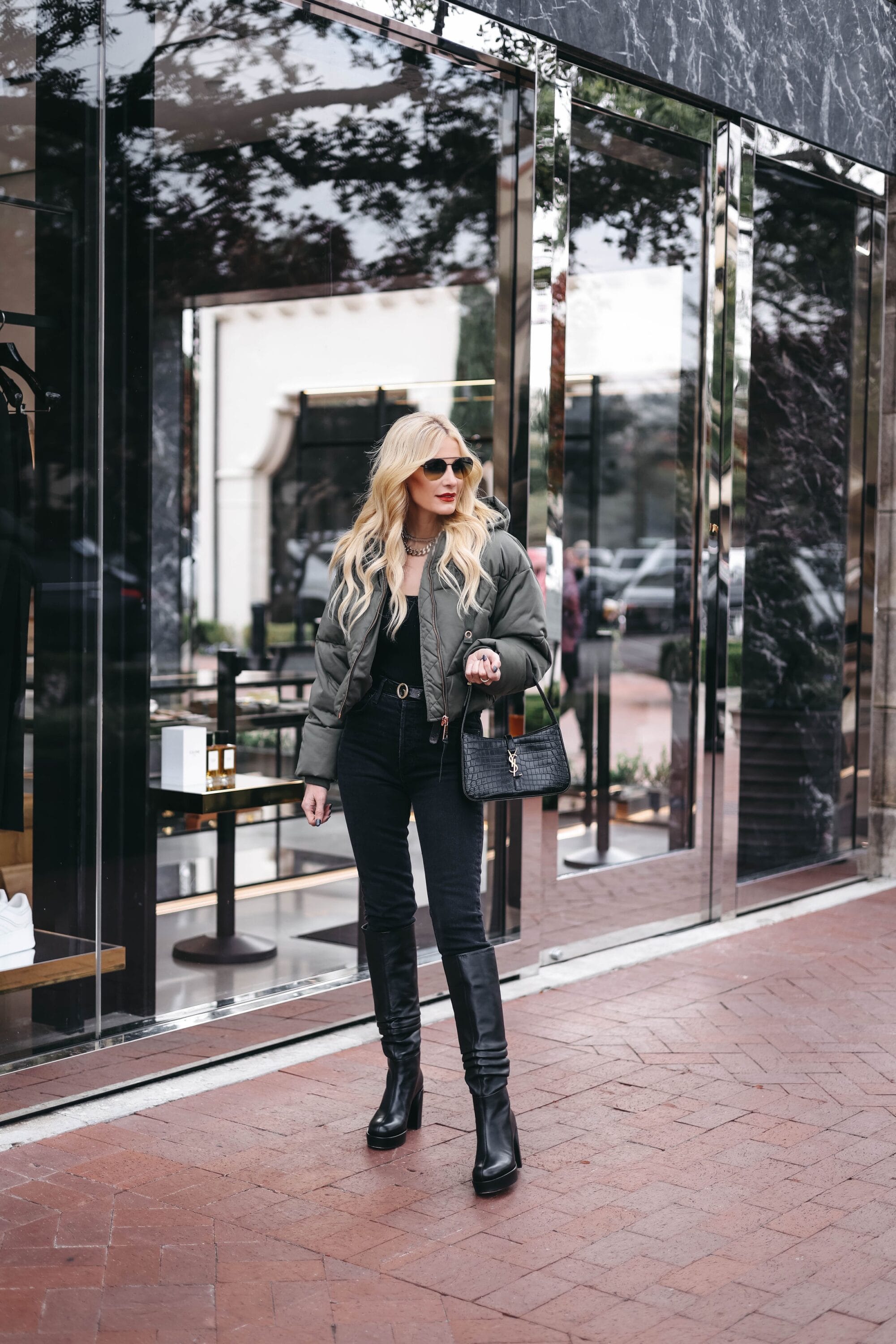 Over 40 Dallas fashion blogger wearing green ouffer jacket with black jeans nad black bodysuit.