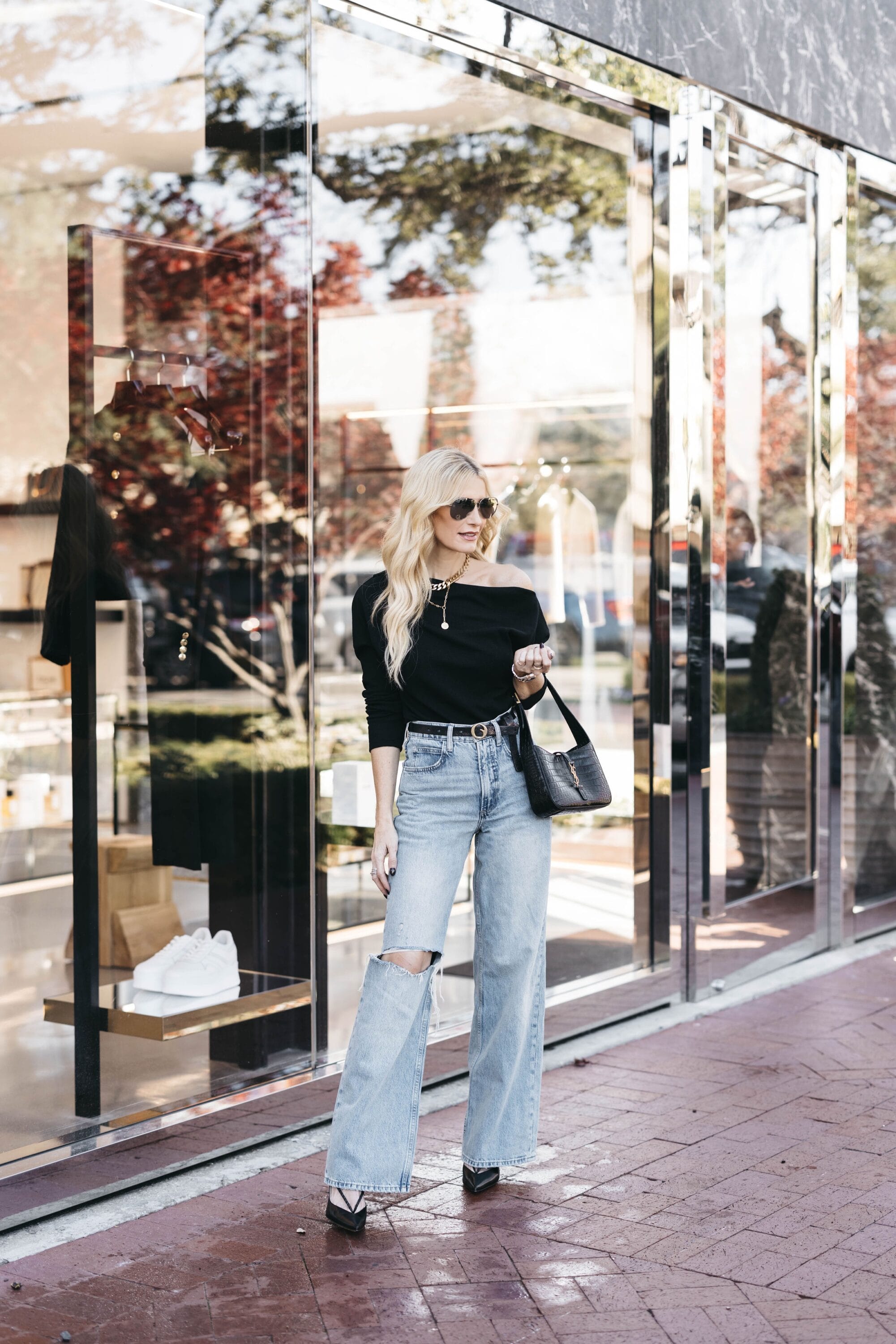 Over 40 dallas influencer wearing baggy denim with a black off the shoulder top as how to style baggy jeans.