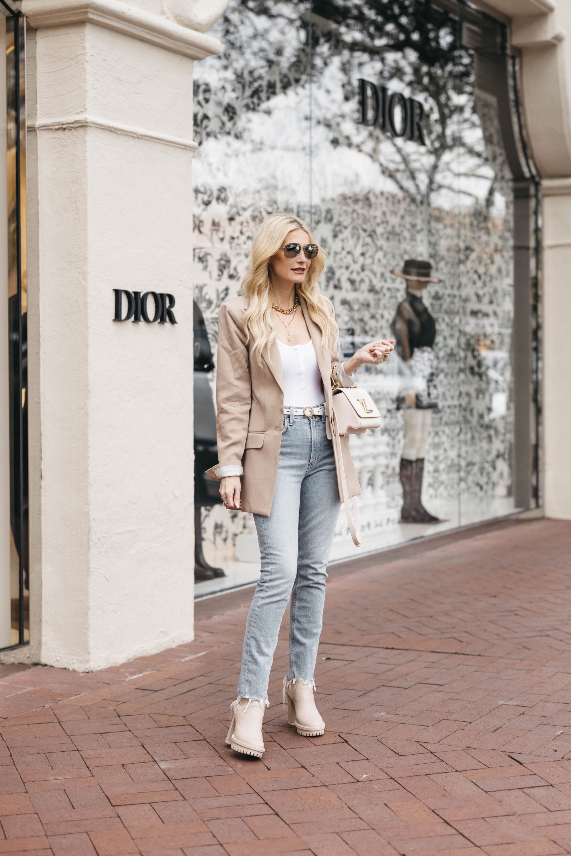 Dallas fashion blogger over 40 wearing neutral oversized blazer with white bodysuit and light wash jeans with chunky ivory boots as one way for how to style a blazer.
