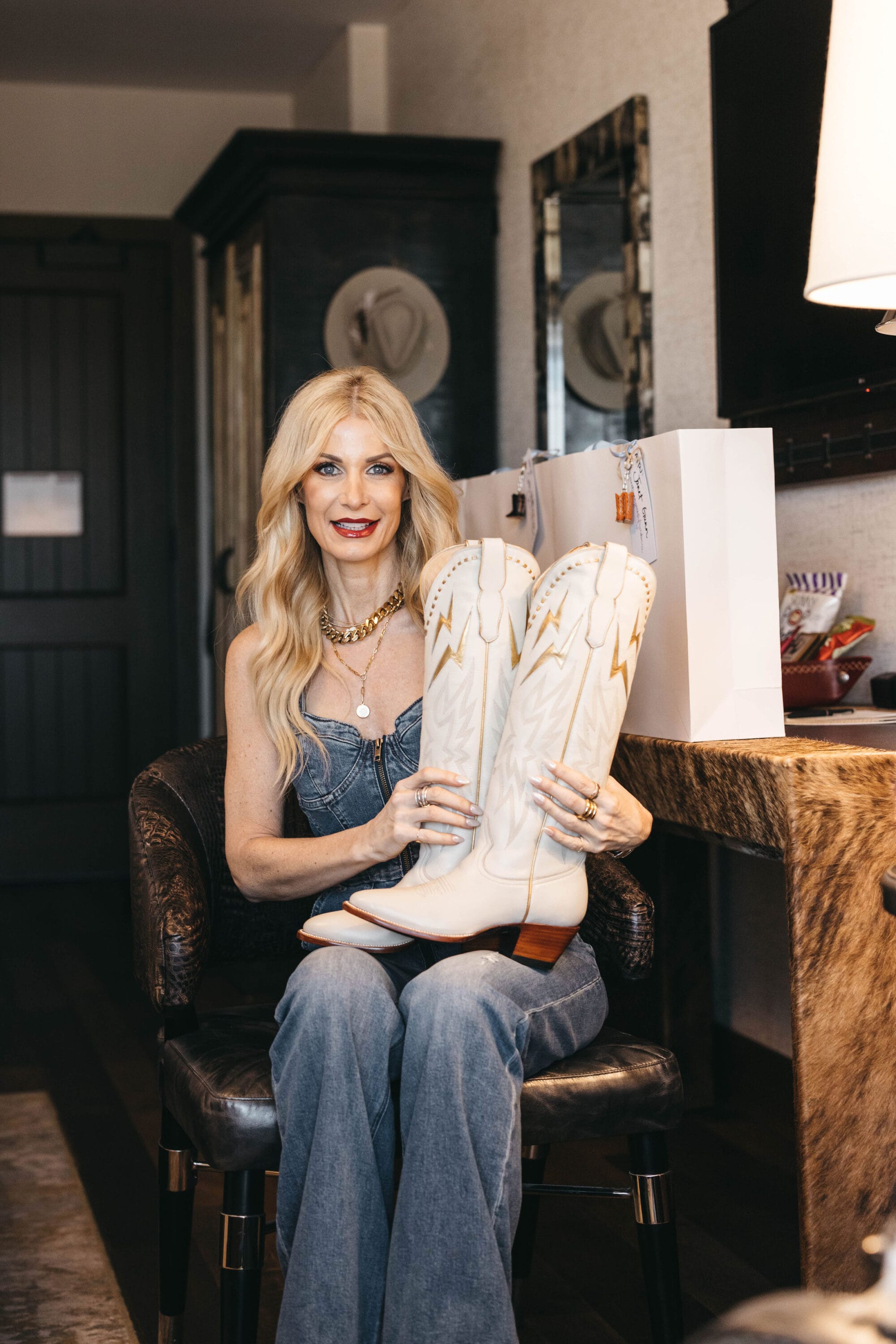 Over 40 Dallas fashion influencer showing ivory cowboy boots from City Boots at Hotel Drover.