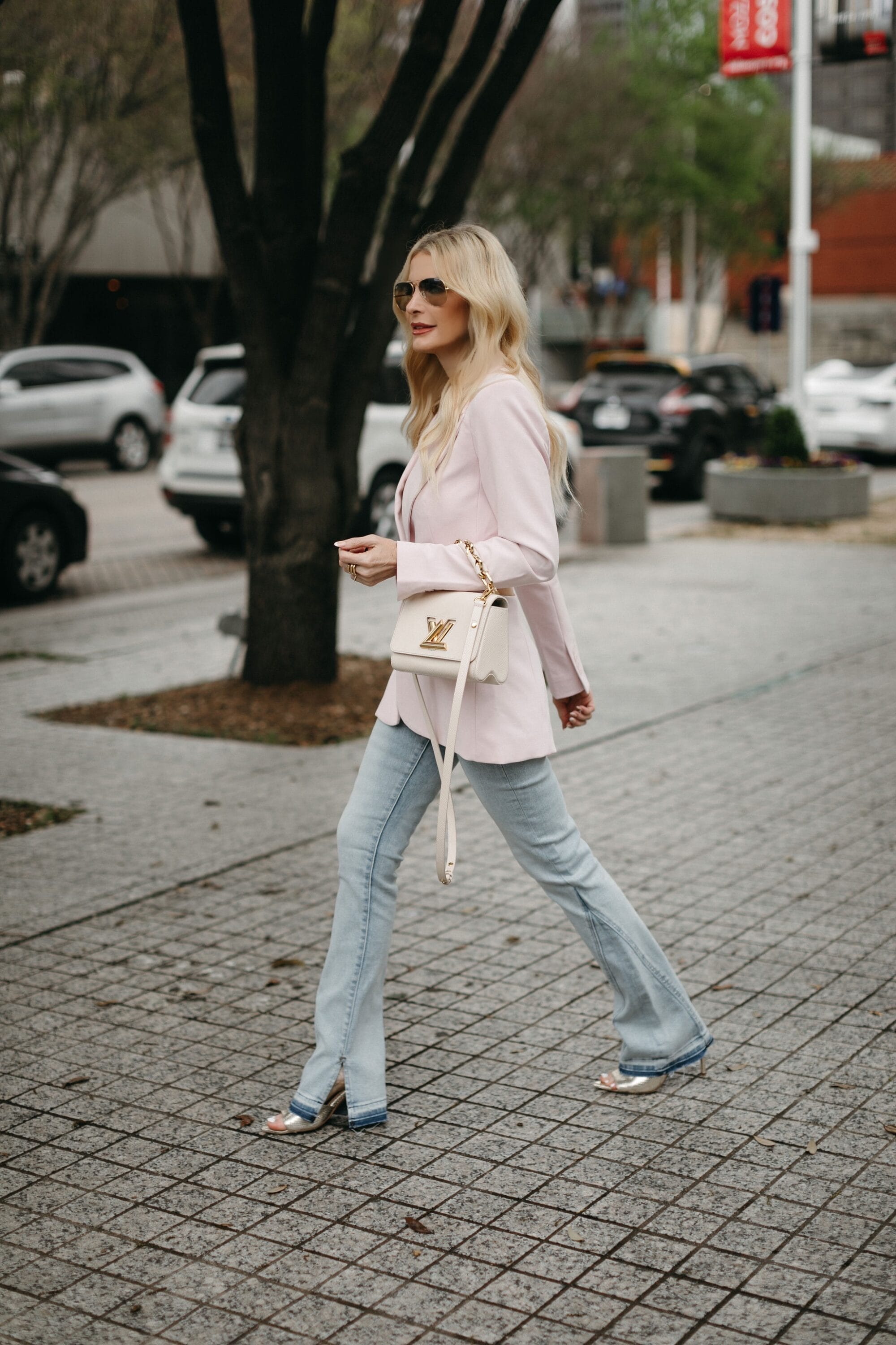 Dallas lady over 40 wearing a cutout blazer with light wash split-hem jeans as one of the top spring denim trends of 2023.