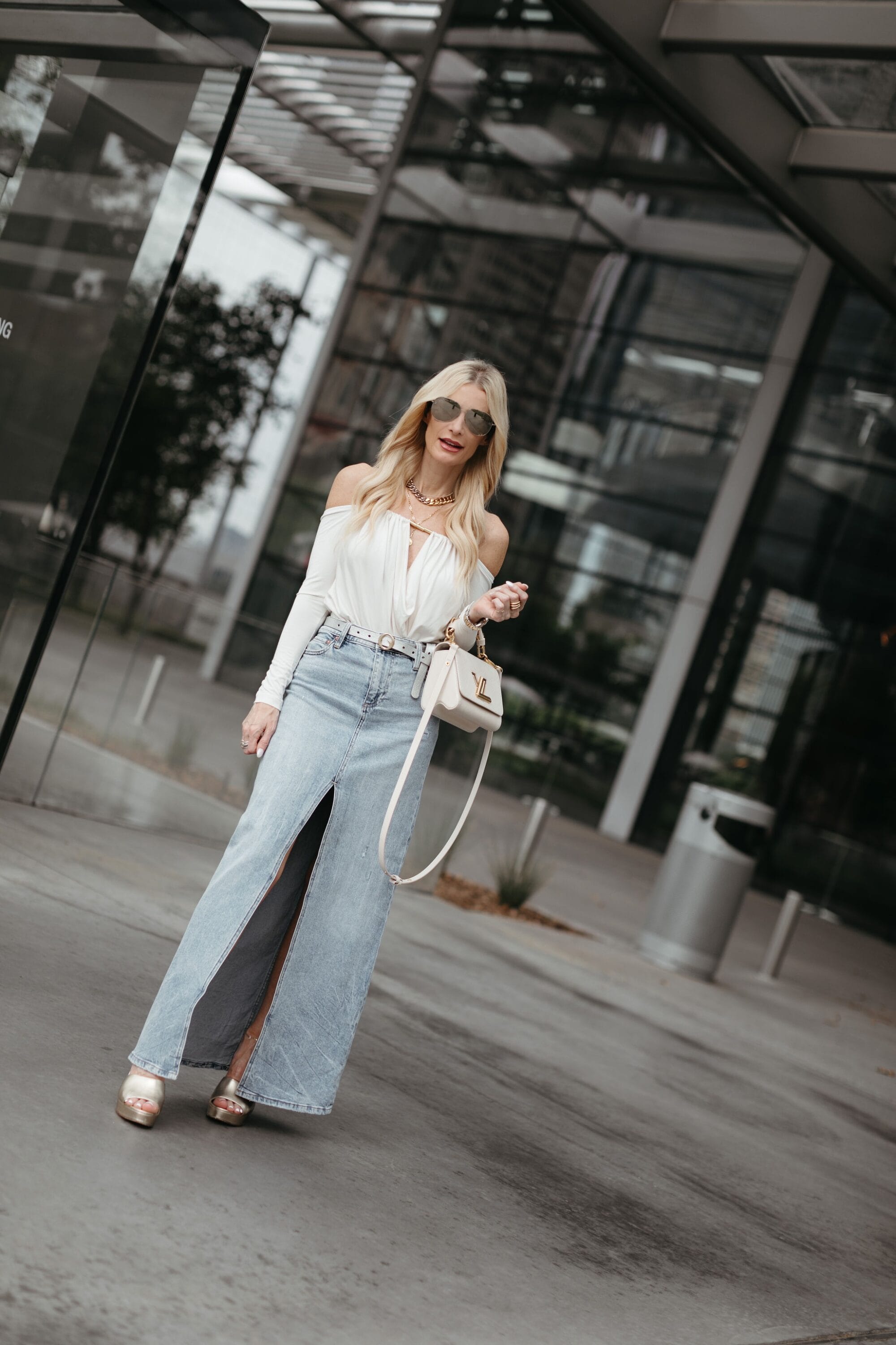 Over 40 fashion blogger showing how to style a denim midi skirt with a white top.