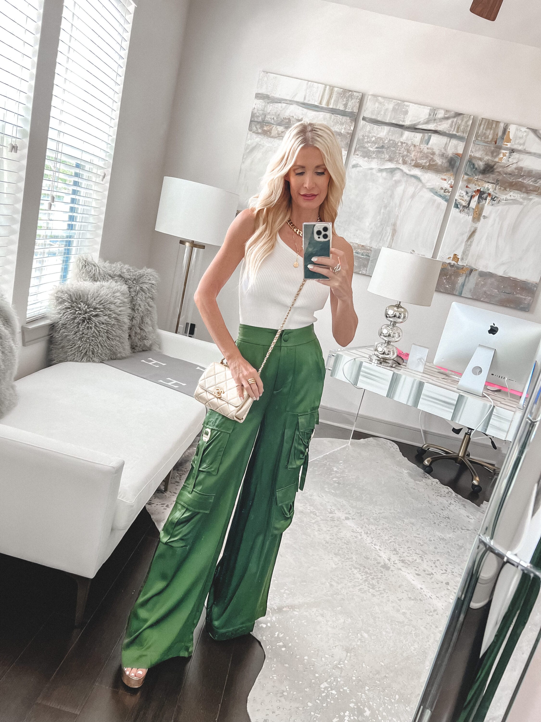 Over 40 fashion influencer wearing green satin cargo pants with a one shoulder top.