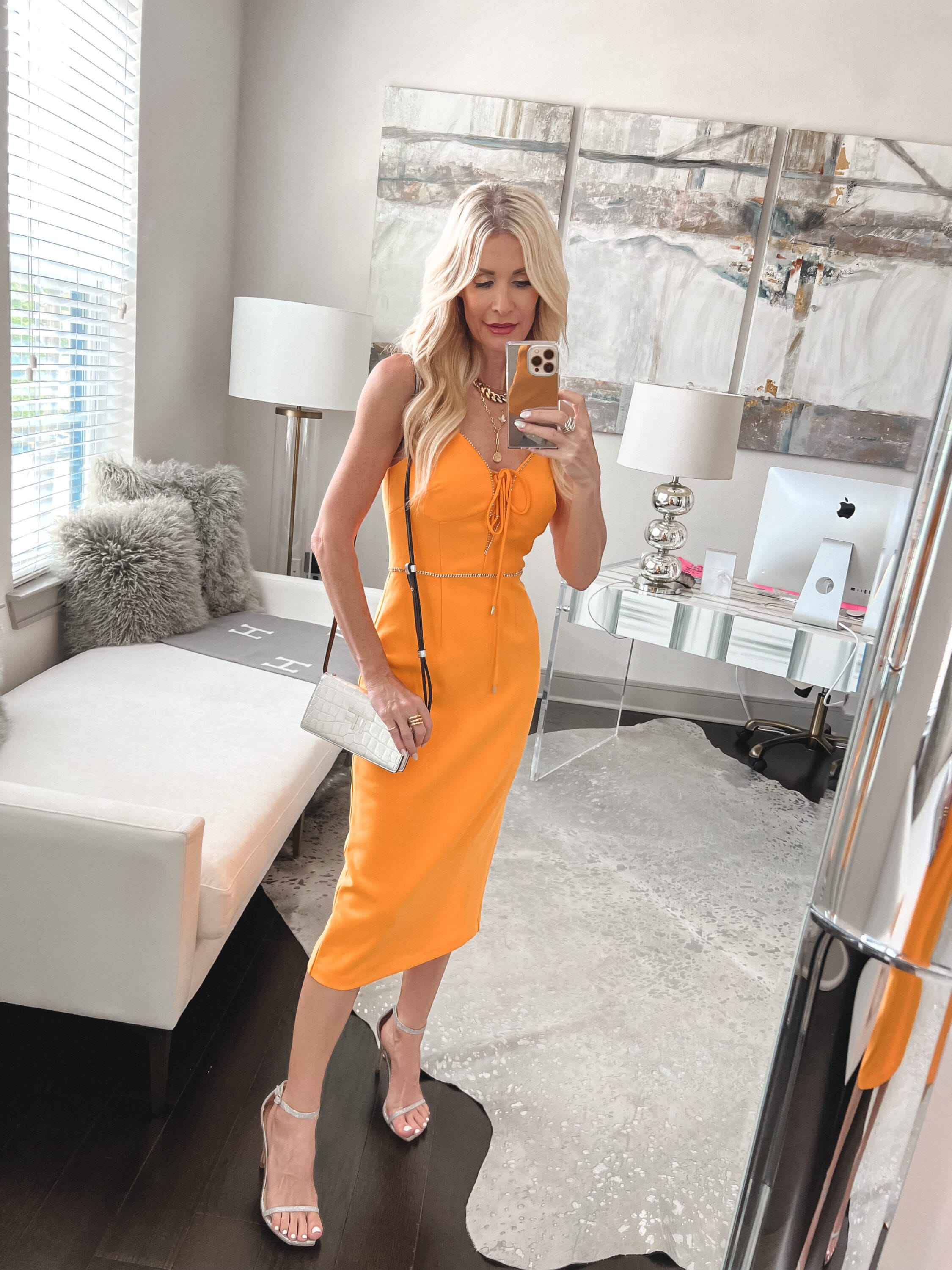 Dallas fashion influencer wearing a gold midi dress with silver rhinestone heels.