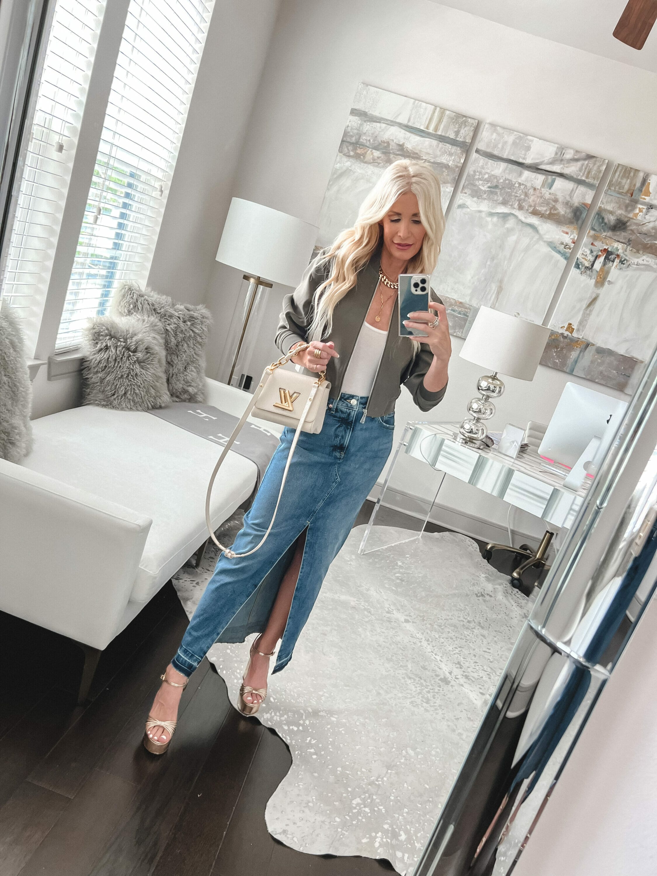 Dallas fashion icon wears a denim midi skirt with a white top and cropped olive blazer as one of the best transitional jackets.