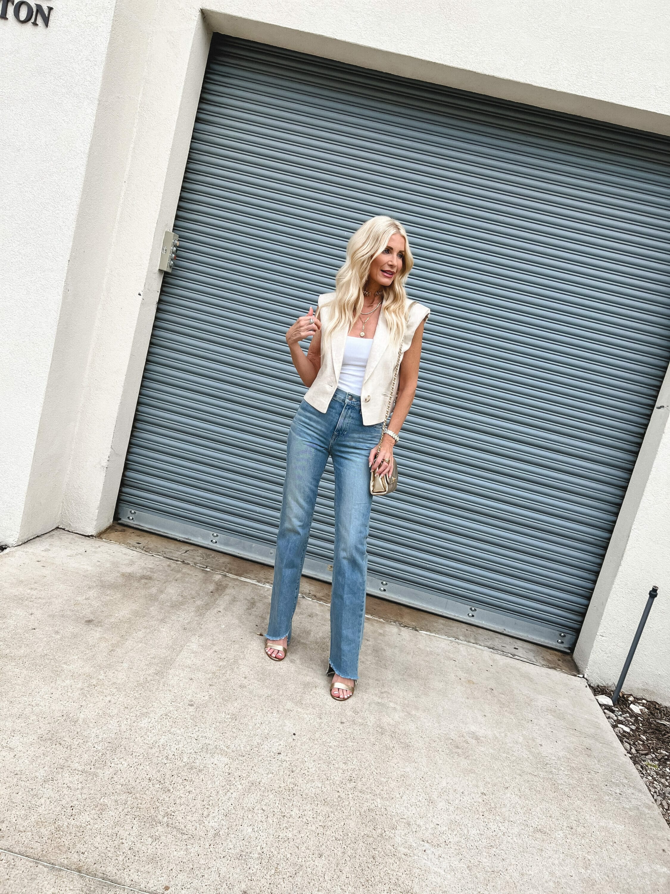 Over 40 fashion blogger from Dallas wearing a linen vest with a white bodysuit and straight leg jeans.