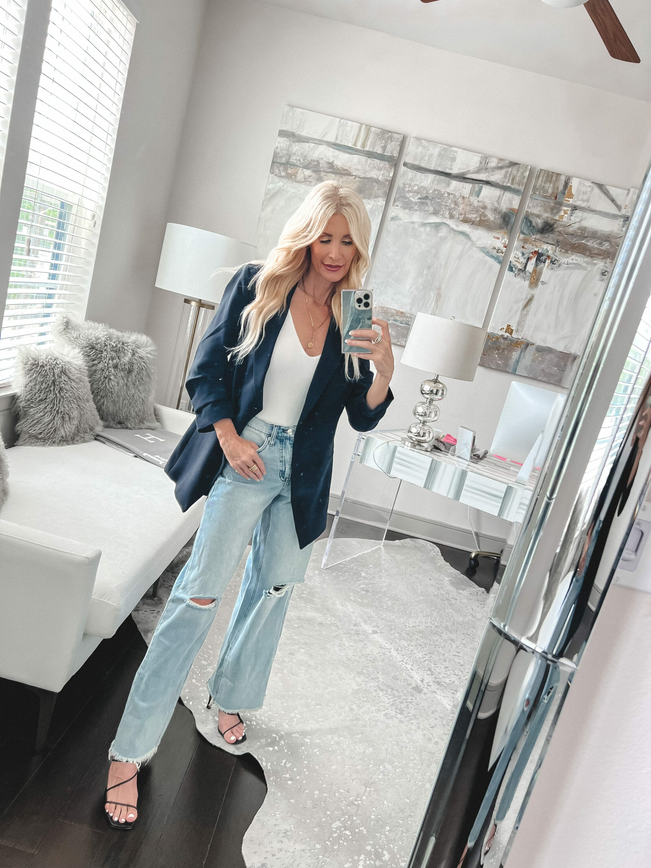 Dallas fashion stylist over 40 wearing a black blazer with a white bodysuit and wide leg jeans, all as surprising summer favorites from Walmart.